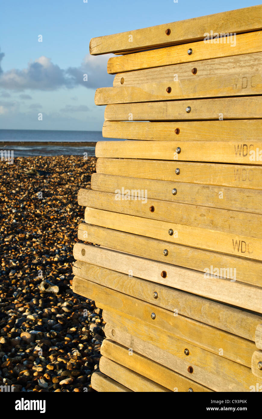 A stack of traditional deck chairs on Worthing beach in the morning sun. Picture by Julie Edwards Stock Photo