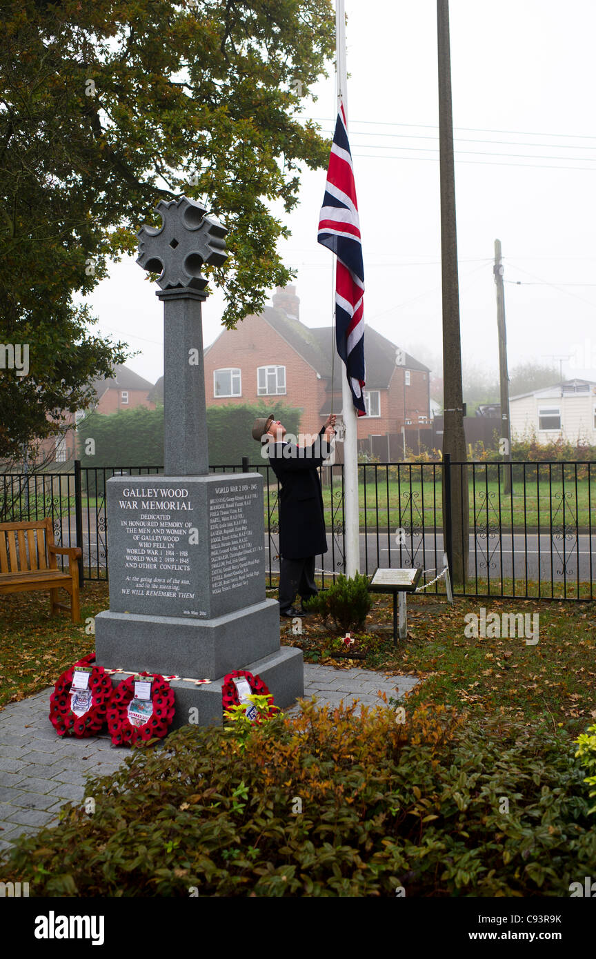 11th November 2011 Galleywood, Essex. A cold misty morning greeted the local people at the Galleywood War Memorial to pay their respects to the war dead. Cllr Neville Paul lowers the flag to half-mast. Stock Photo