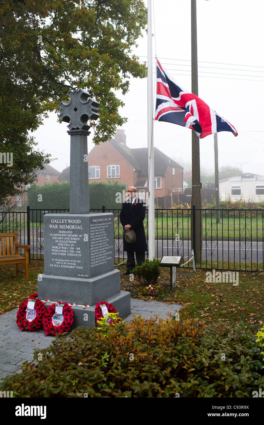 11th November 2011 Galleywood, Essex. A cold misty morning greeted the local people at the Galleywood War Memorial to pay their respects to the war dead. Cllr Neville Paul stands next to Union Jack at half-mast. Stock Photo