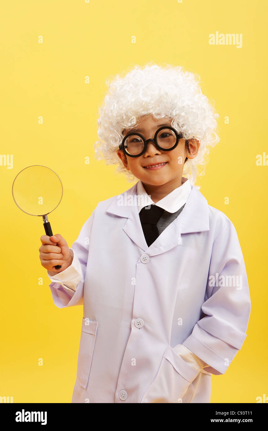 Portrait of boy in scientist uniform holding magnifying glass, smiling  Stock Photo - Alamy