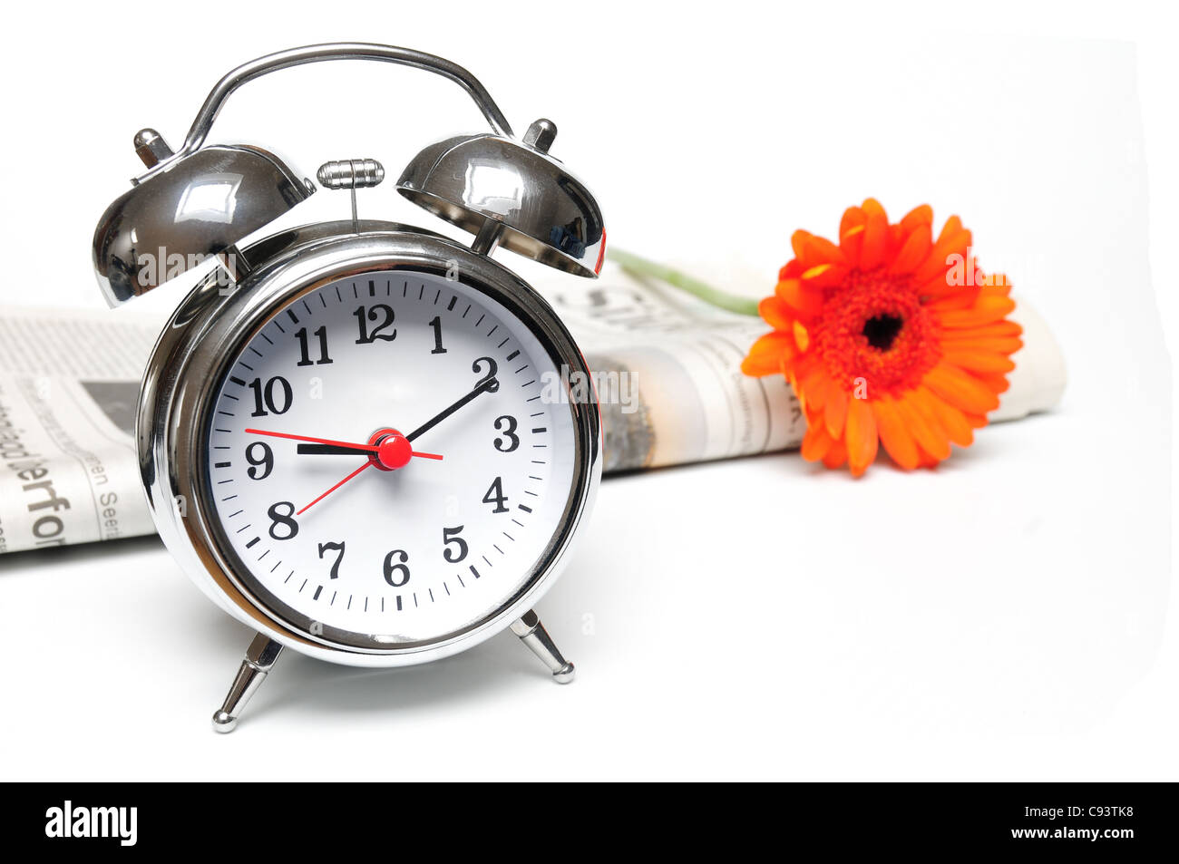 Newspaper, clock and red daisy on white background Stock Photo Alamy