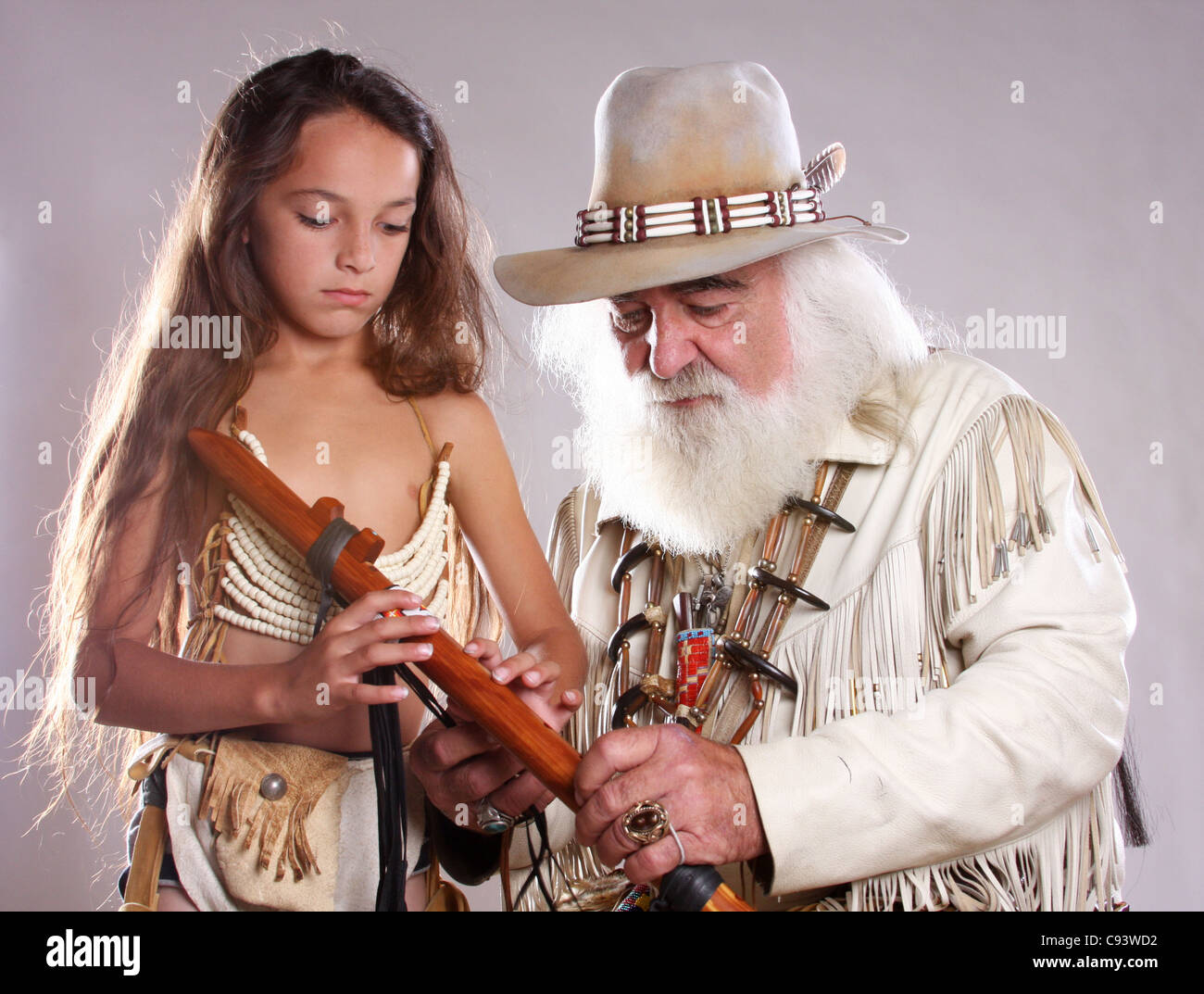 A young Native American Indian boy learning how to play a flute Stock Photo