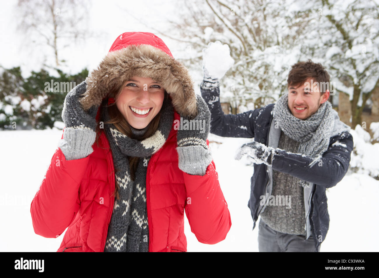 Young couple having snowball fight Stock Photo