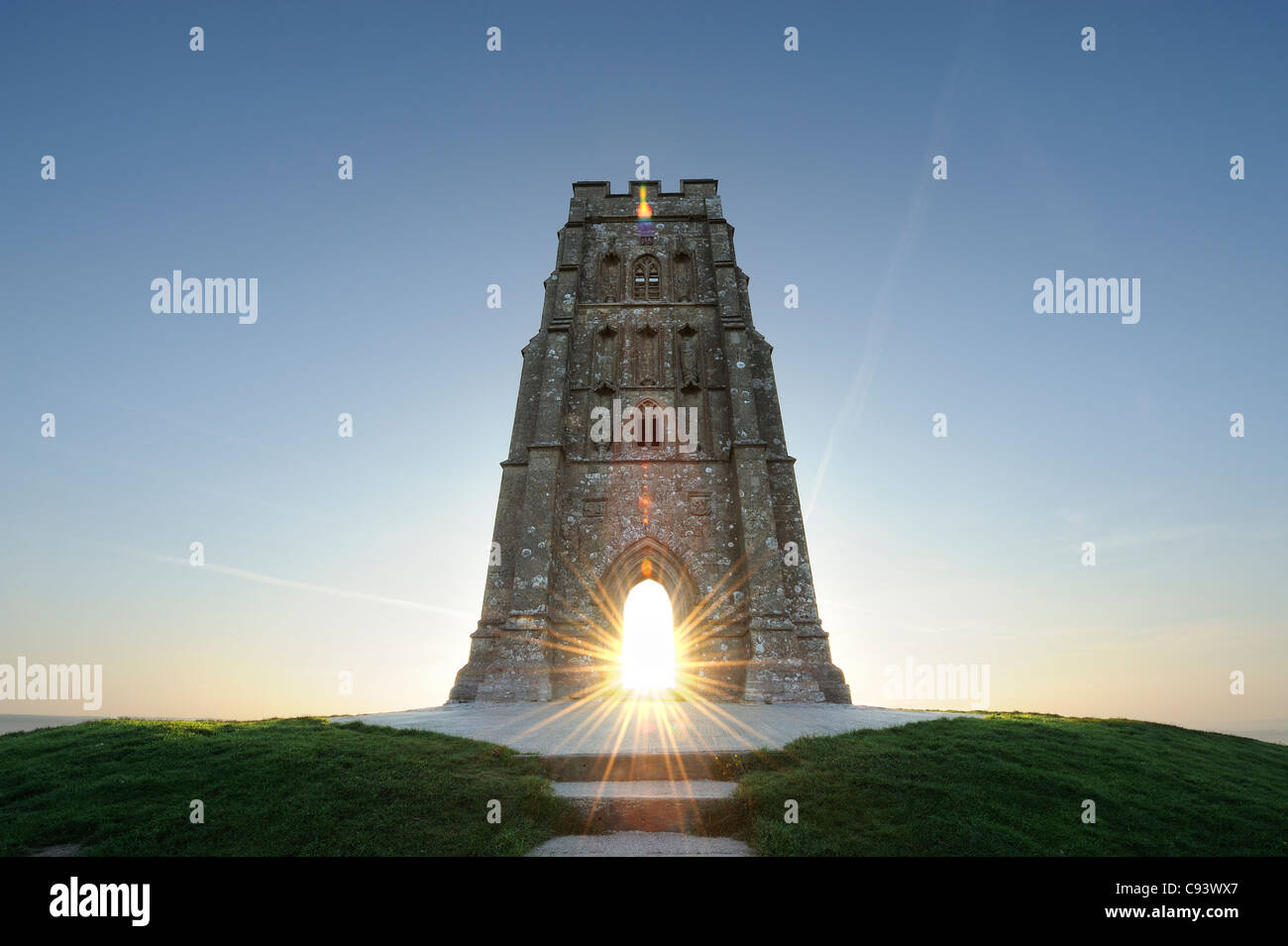 St Michael's tower atop Glastonbury Tor, Somerset, with the rising sun visible through the tower's archway. Stock Photo