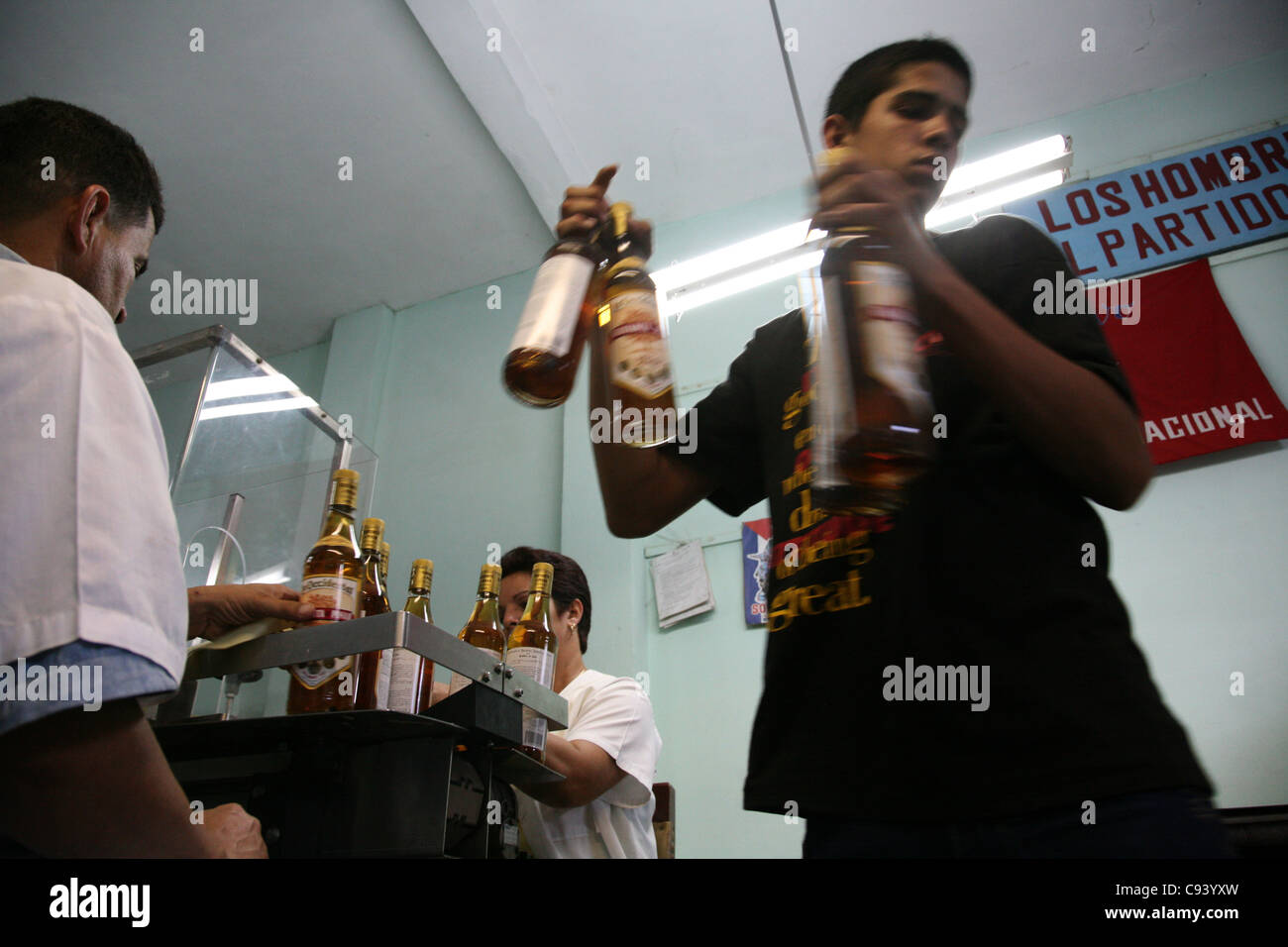Worker carries ready rum bottles at the rum factory Fabrica de Bebidas