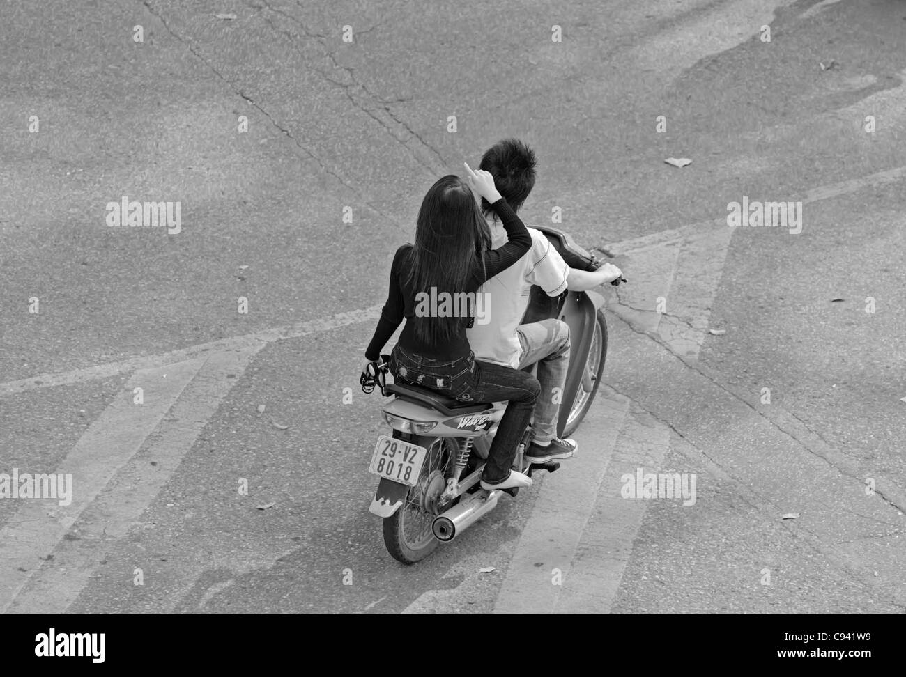 Asia, Vietnam, Hanoi. Hanoi old quarter. Vietnamese couple riding on a small motorbike through Hanoi. Stock Photo
