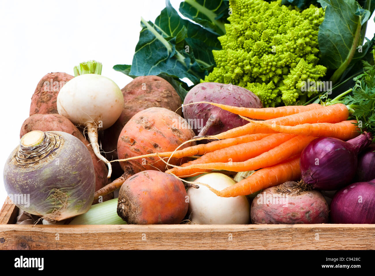 Box of mixed vegetables: turnips, carrots, swede, potatoes, beetroots, red onions, leek and Roman cauliflower Stock Photo