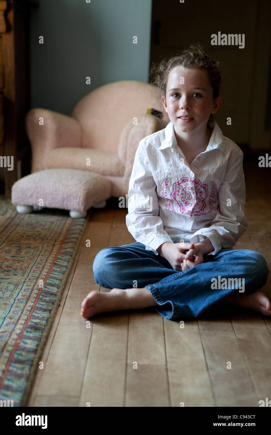Young girl sitting on the floor crossed legged hi-res stock photography ...