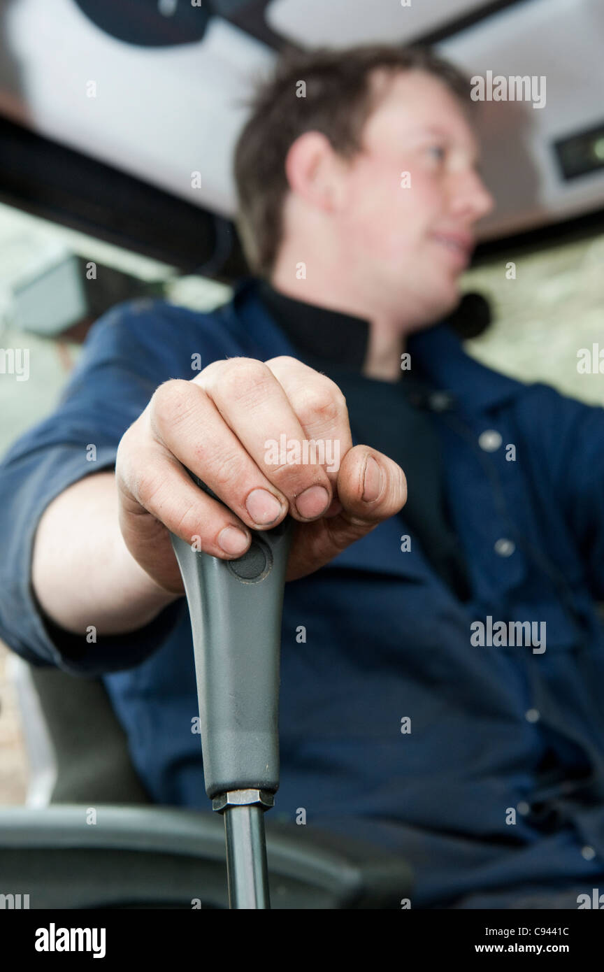 Tractor driver operating loader joystick control Stock Photo