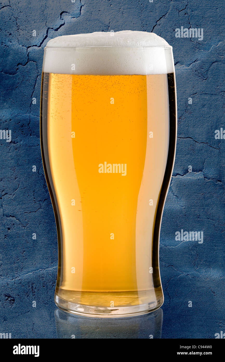 ice cold beer against a blue background Stock Photo Alamy