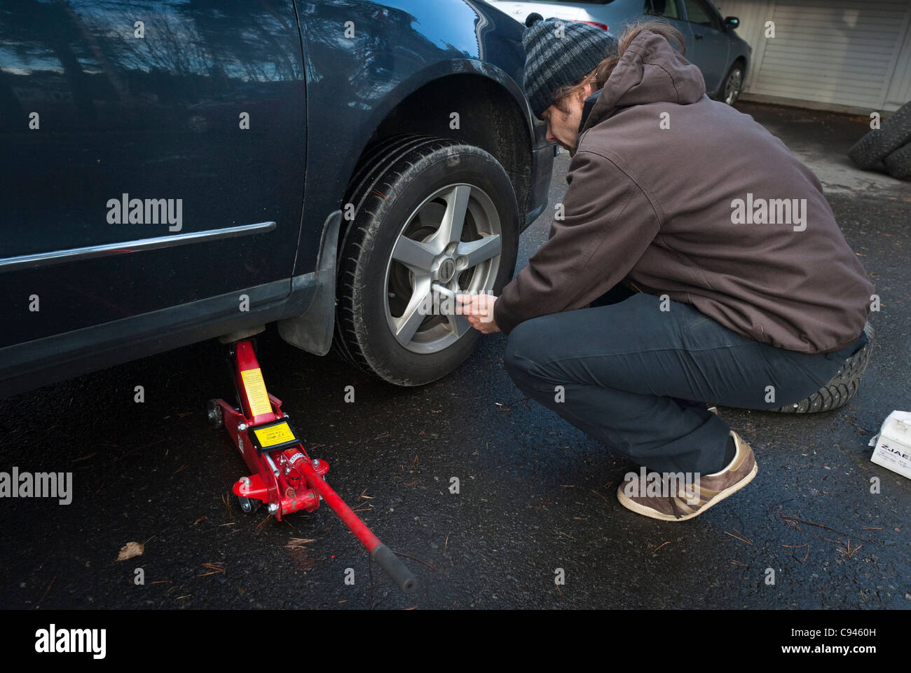 A man changing the summer tires to winter tires, anticipating the Finnish winter Stock Photo Alamy