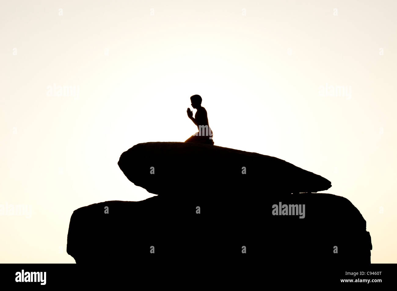 Indian man offering prayers to the sun at sunset. Silhouette. India Stock Photo