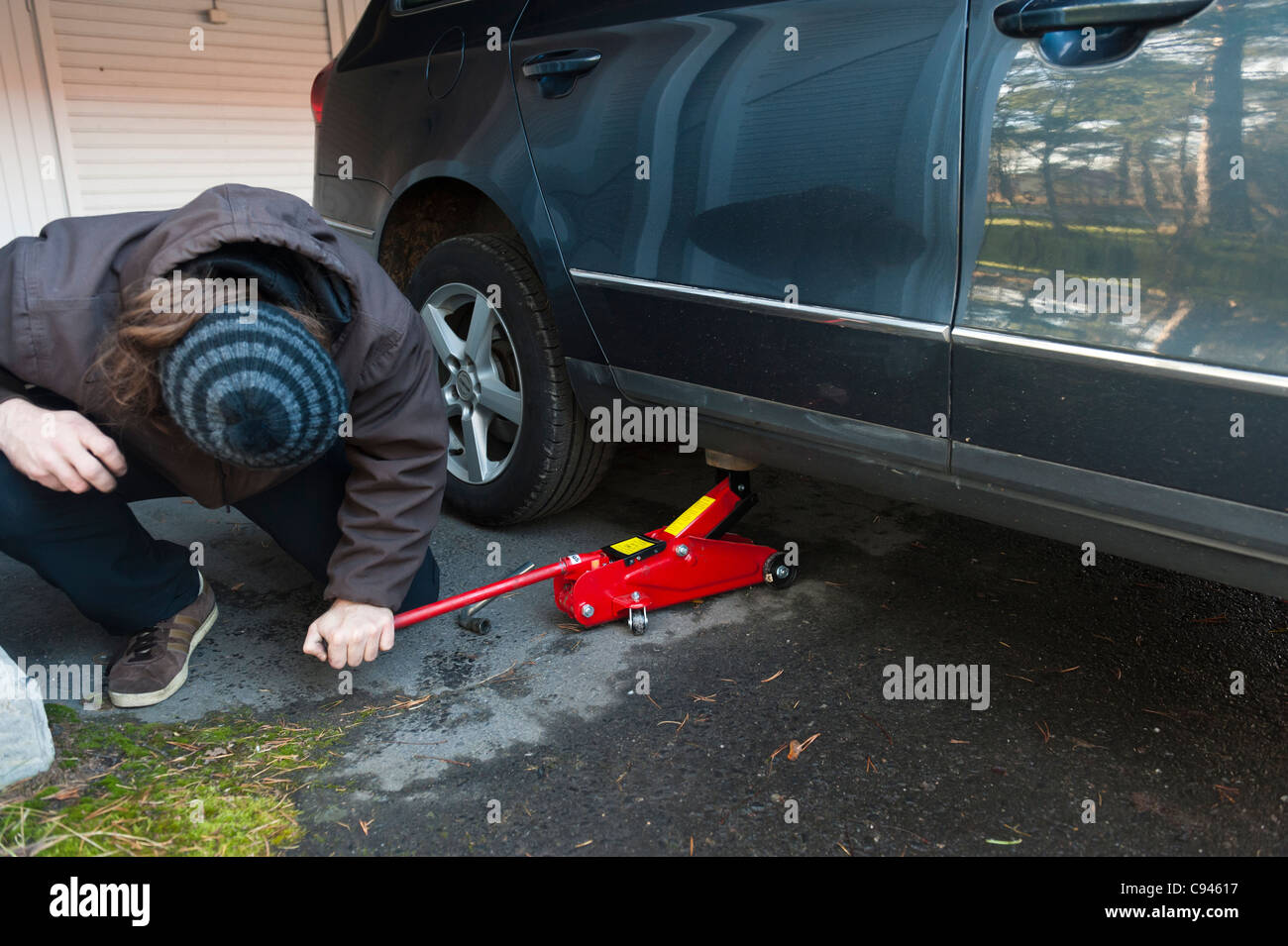A man changing the summer tires to winter tires, anticipating the ...