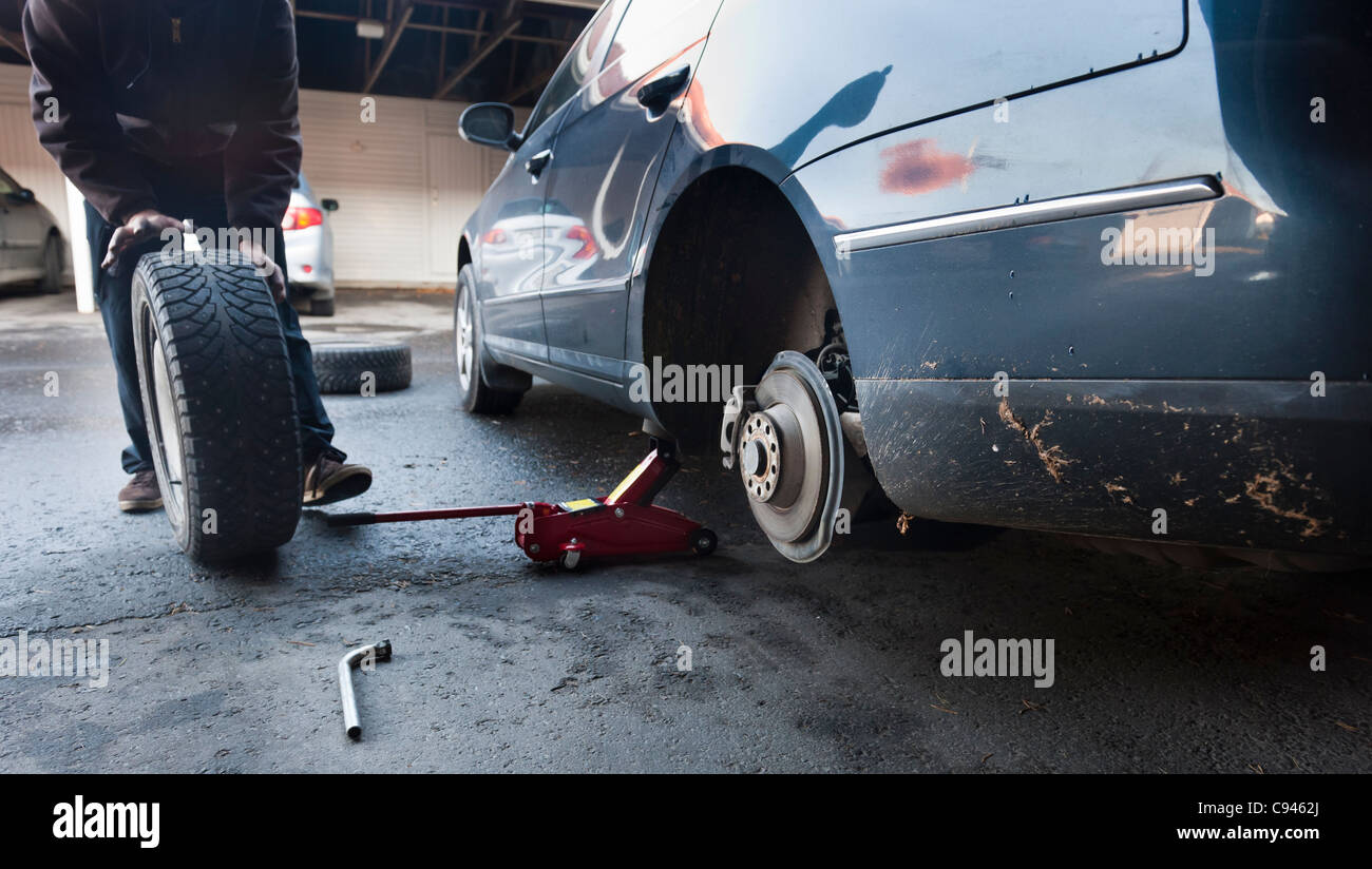 A man changing the summer tires to winter tires, anticipating the Finnish winter Stock Photo Alamy