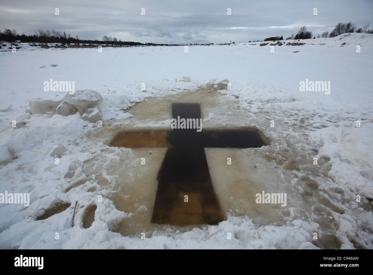 Cross-shaped ice hole called the Jordan for the Epiphany bathing in the Velikaya River at Vybuty Pogost near Pskov, Russia. Stock Photo