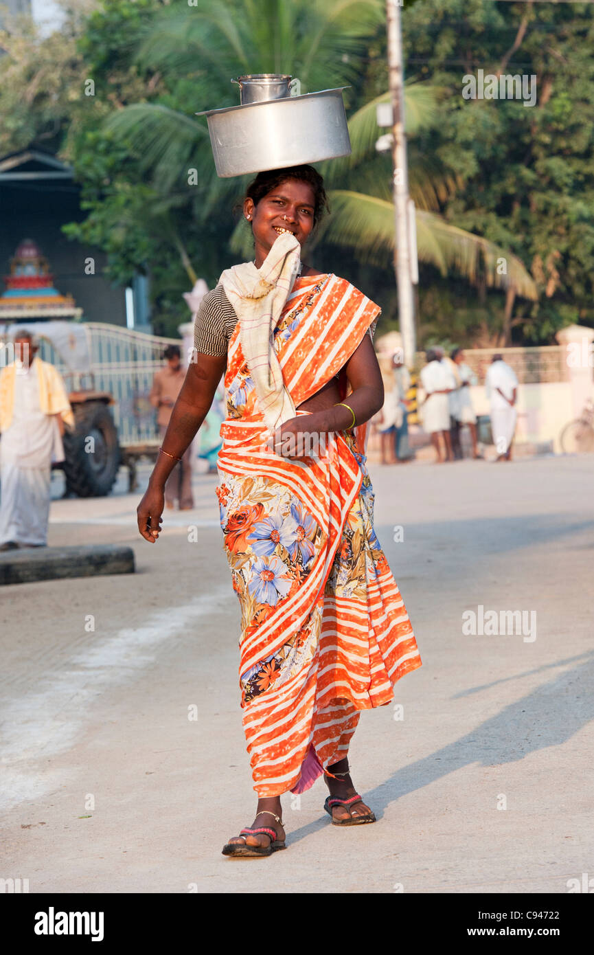 Lower caste indian women a carrying pot of rice on her head. Andhra Pradesh, India Stock Photo