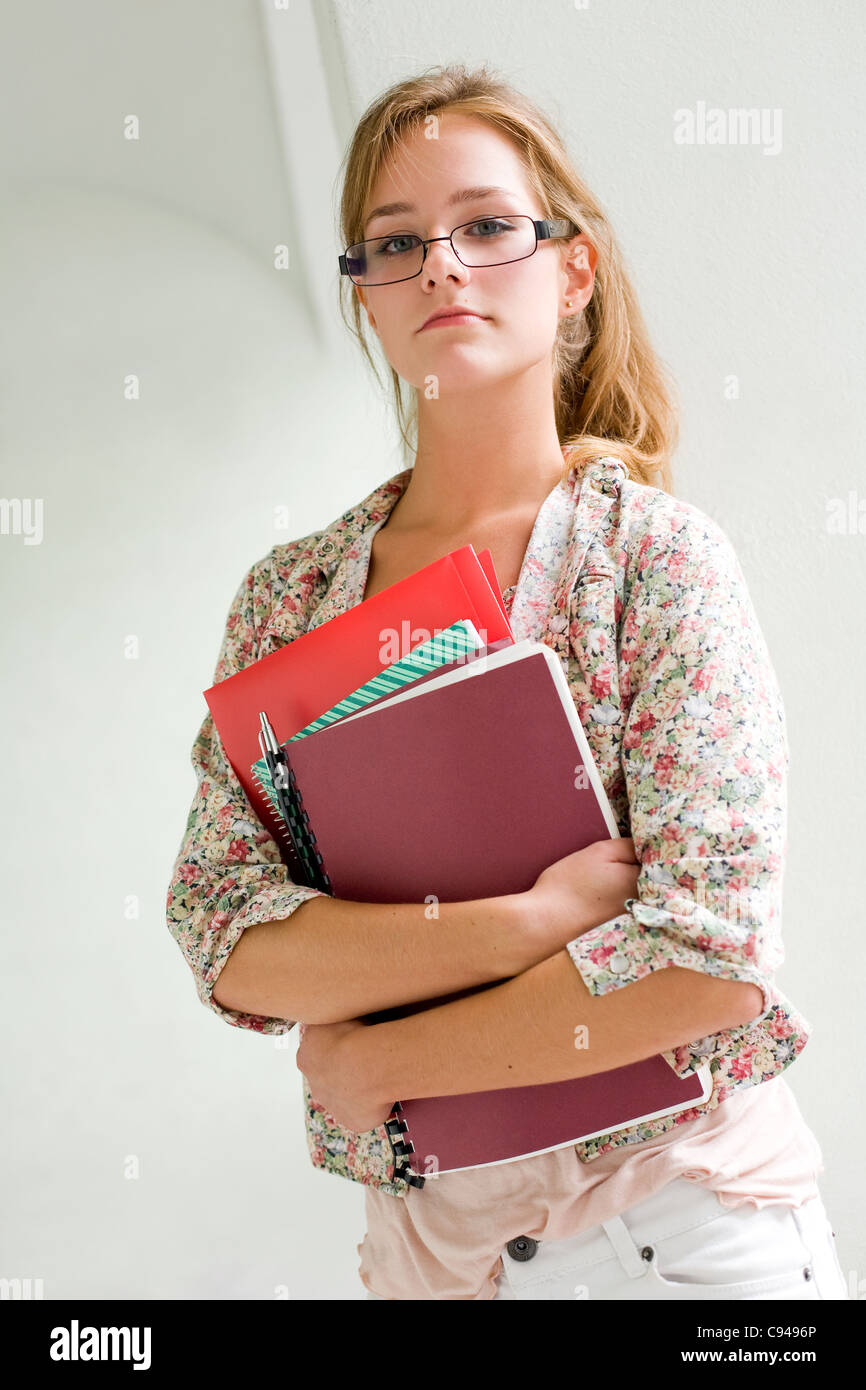 Portrait of cute young blond student girl holding exercise books Stock ...