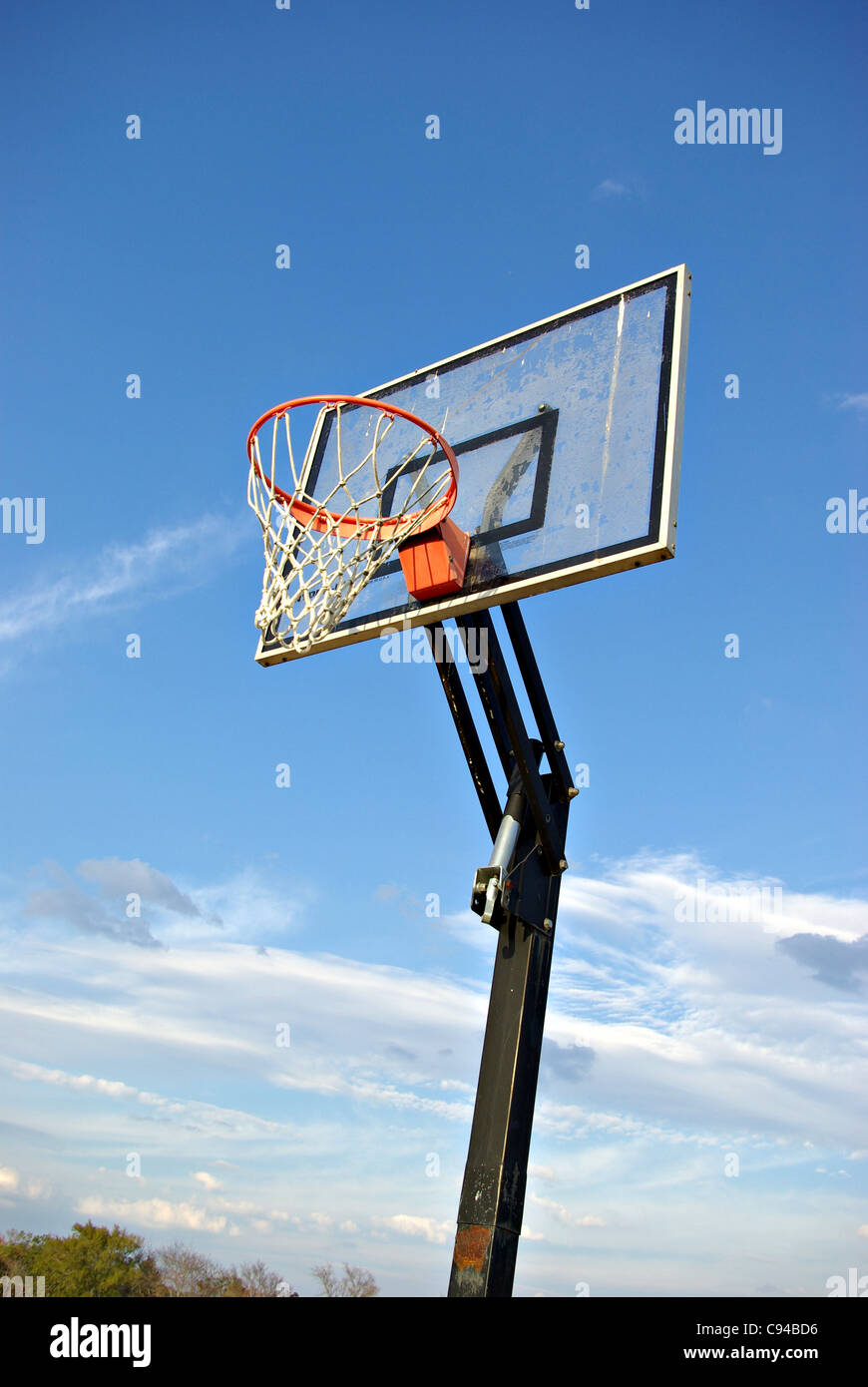 A basketball goal with the sky for a background out in the country. Stock Photo