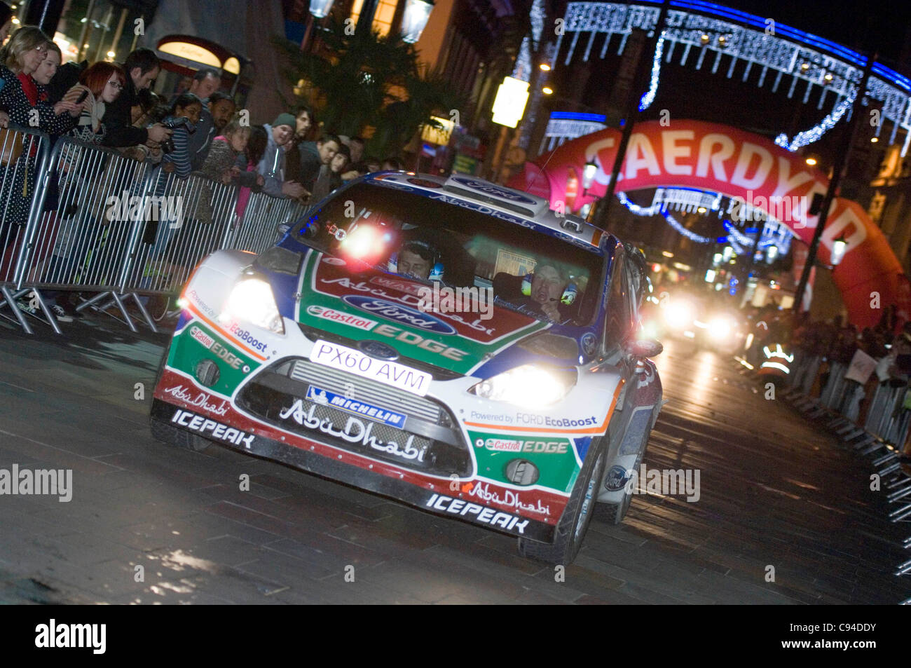Jari-Matti Latvala (Finland) and his co-Driver Mikka Anttila (Finland) in their Ford Abu Dhabi World Rally Team Ford Fiesta RS WRC making their way through the centre of Cardiiff tonight on day 3 of the FIA WRC Wales Rally GB. Stock Photo