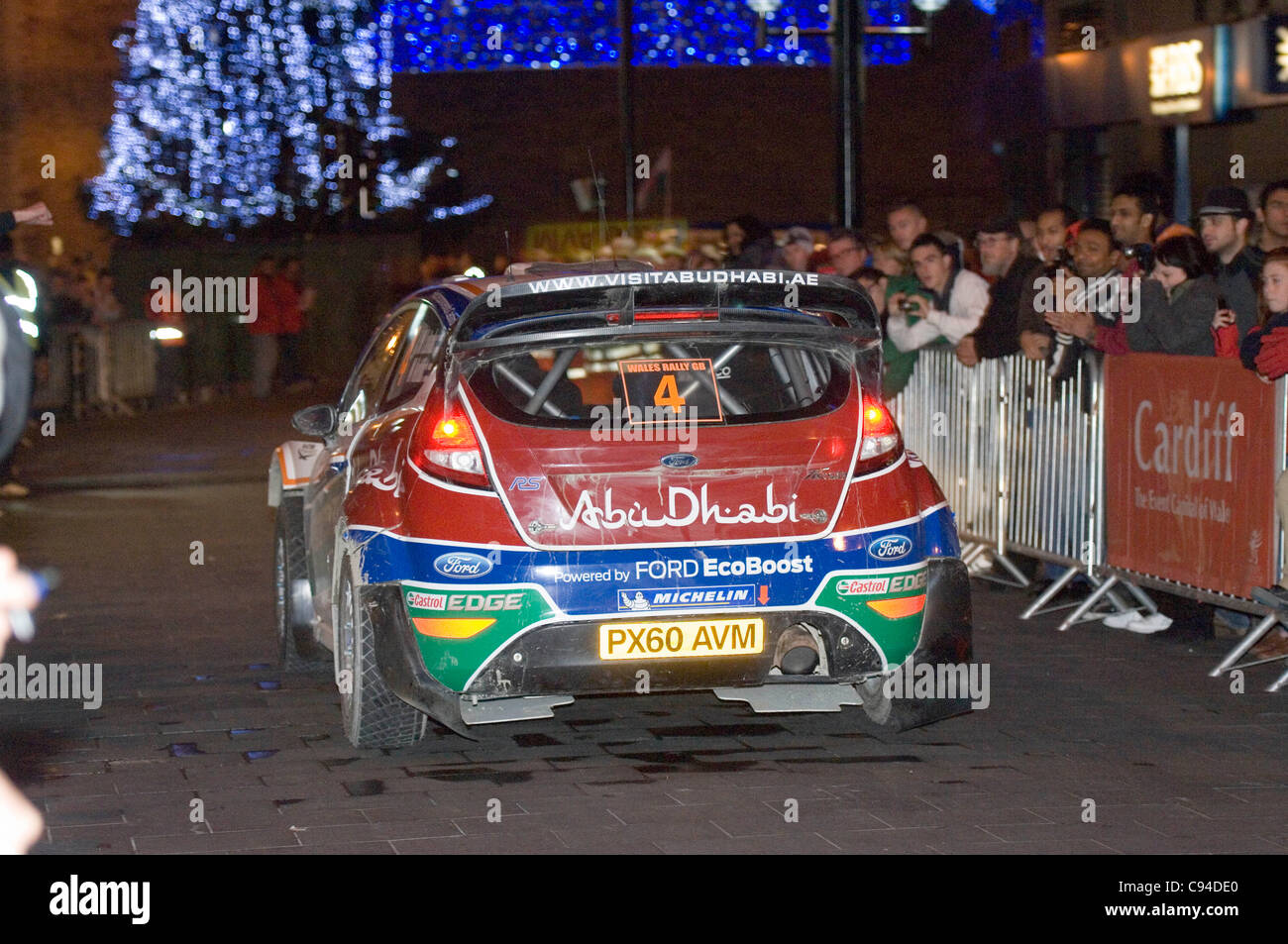 Jari-Matti Latvala (Finland) and his co-Driver Mikka Anttila (Finland) in their Ford Abu Dhabi World Rally Team Ford Fiesta RS WRC making their way through the centre of Cardiiff tonight on day 3 of the FIA WRC Wales Rally GB. Stock Photo