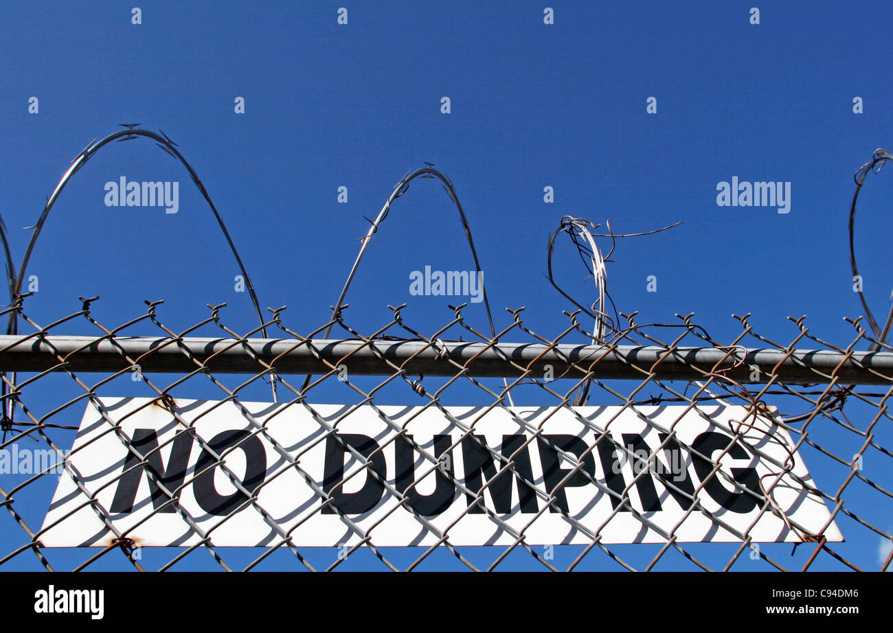 no dumping sign with barb wire fence Stock Photo