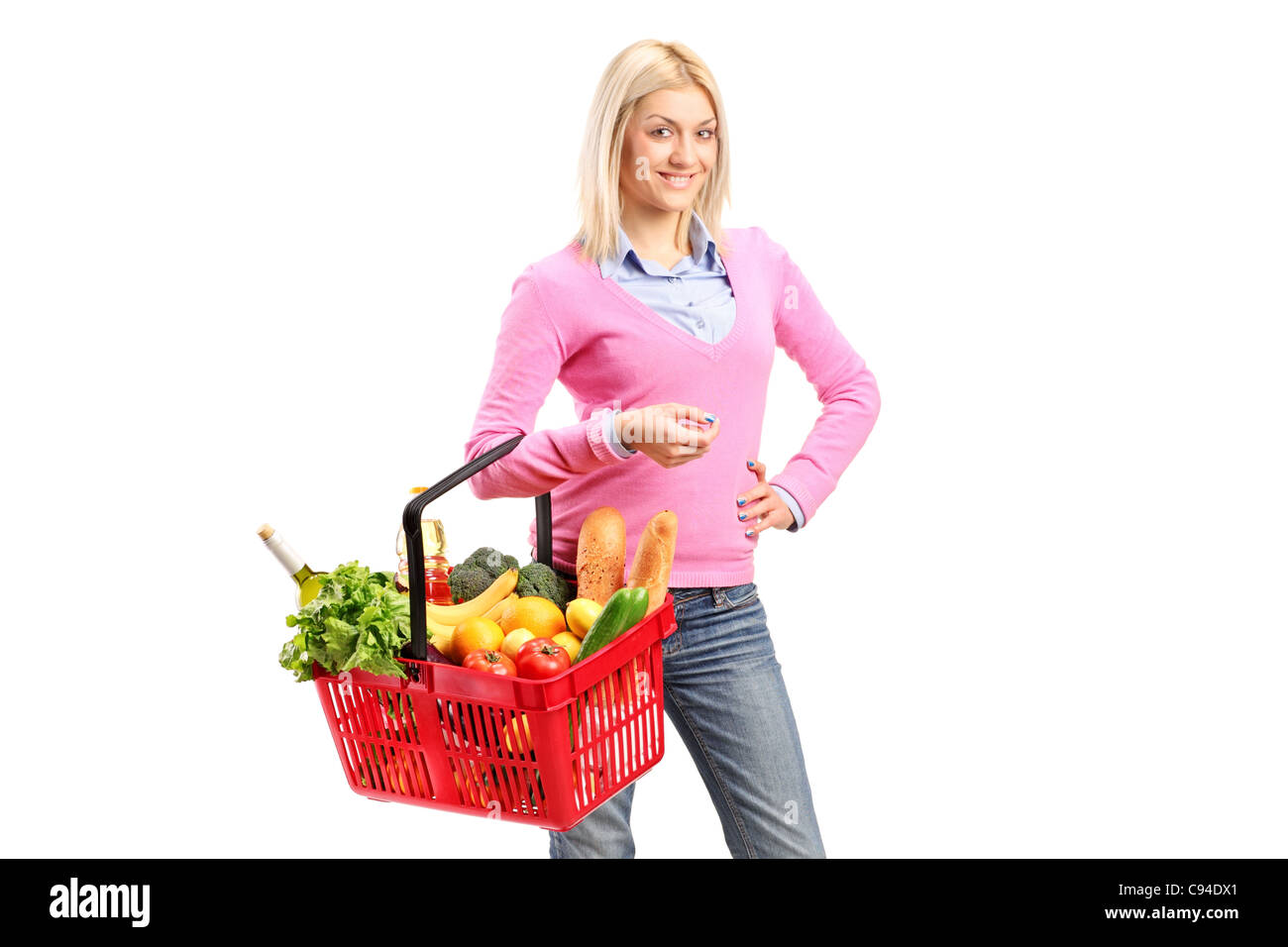 A young woman holding a full shopping basket Stock Photo