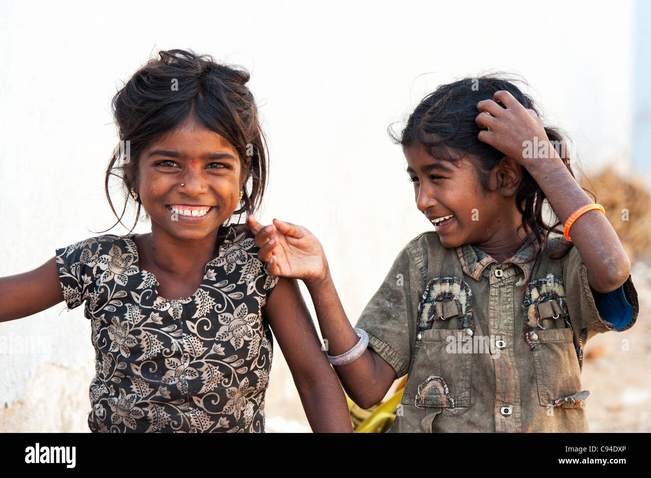 Poor Indian nomadic beggar girls having fun laughing in an indian street Stock Photo