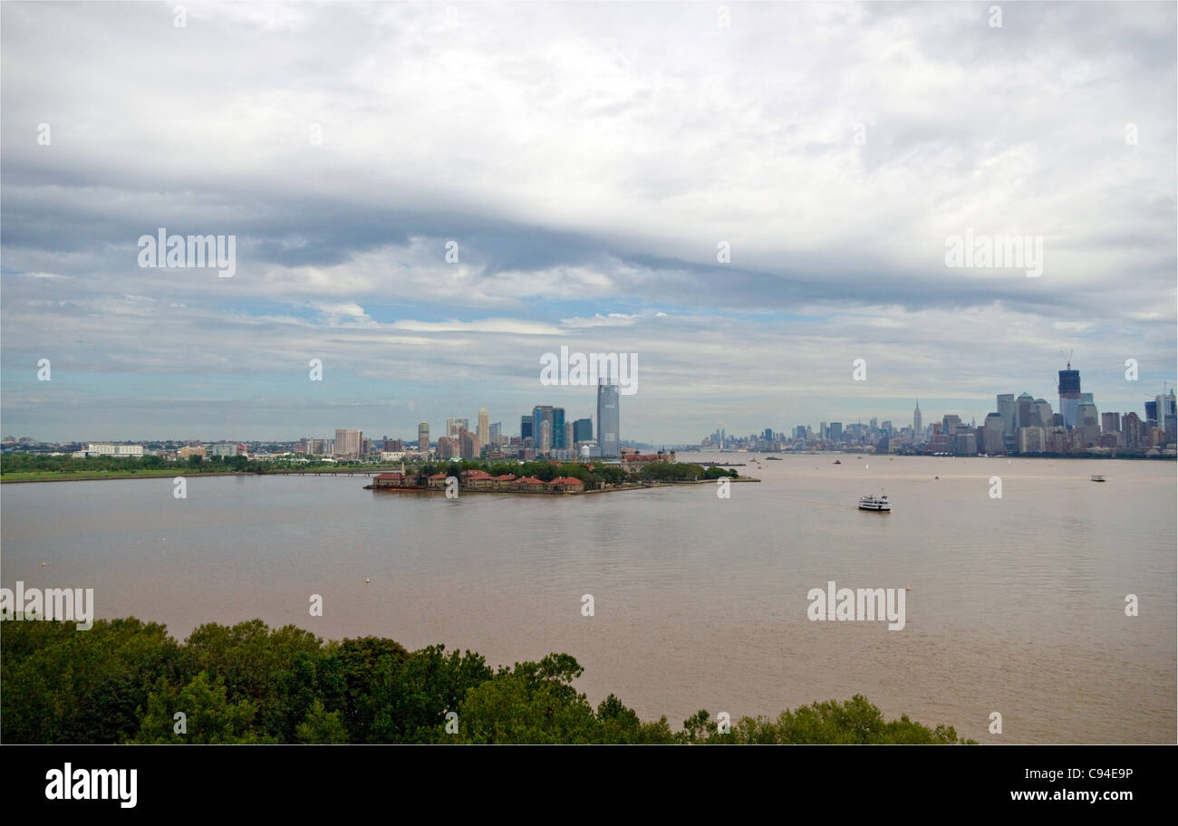 View of South side of Ellis Island with background of Jersey City, NJ, Hudson River and lower 