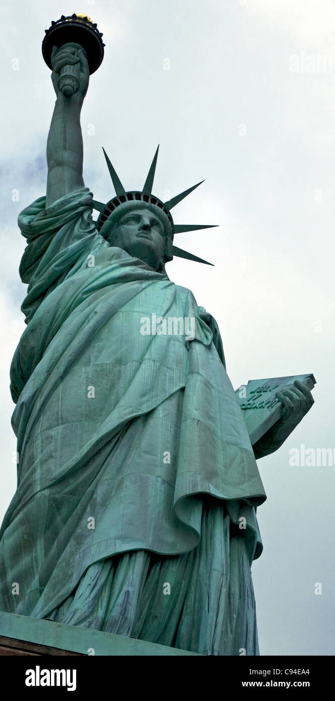 Statue of Liberty with tiny heads of people looking over the pedestal ledge, Crown Torch Tablet