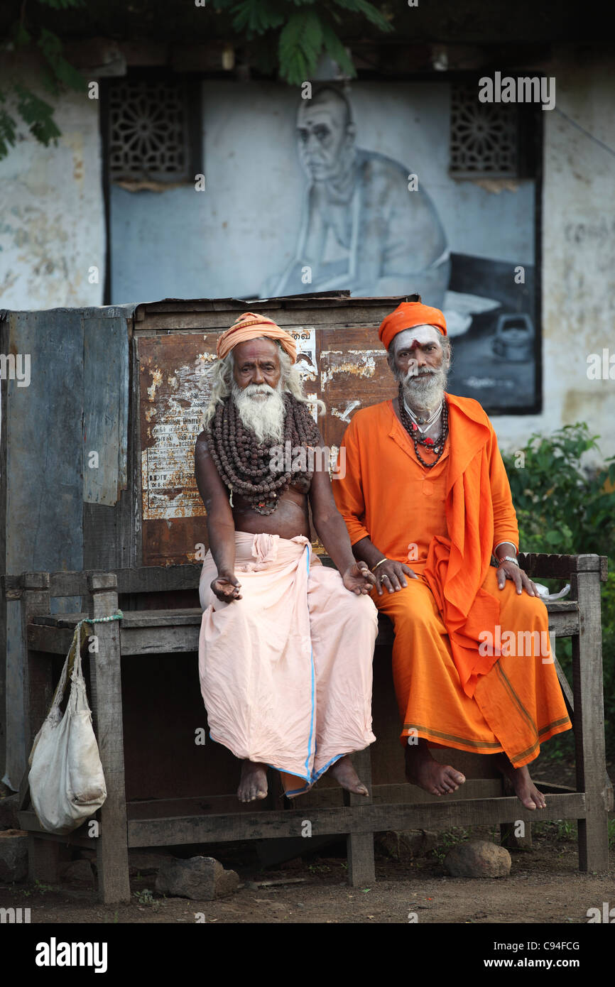 Men sadhus sitting Arunachala South India Ramana Mahasrshi painting on the back Stock Photo