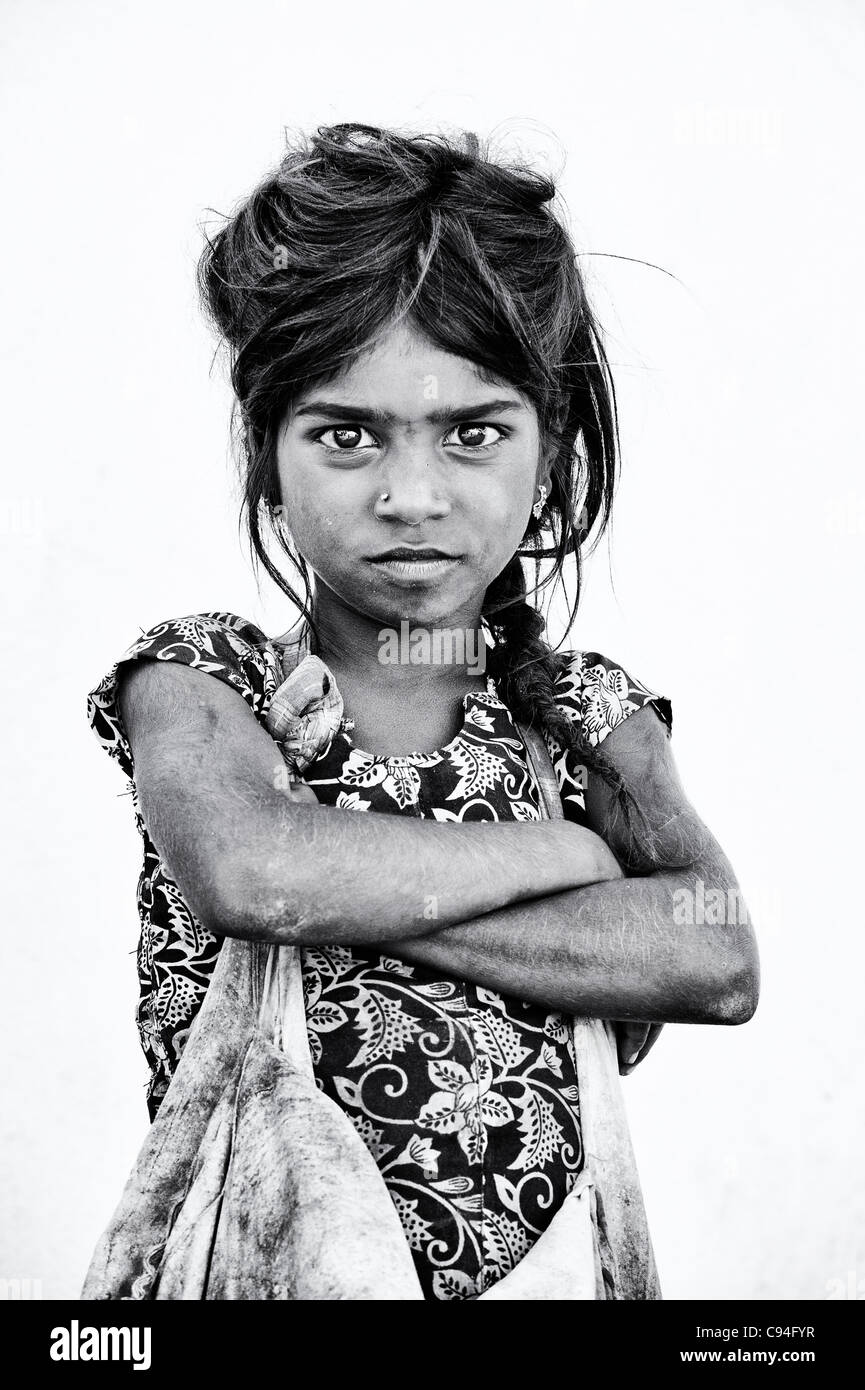Poor Indian nomadic beggar girl staring with folded arms. Black and White Stock Photo