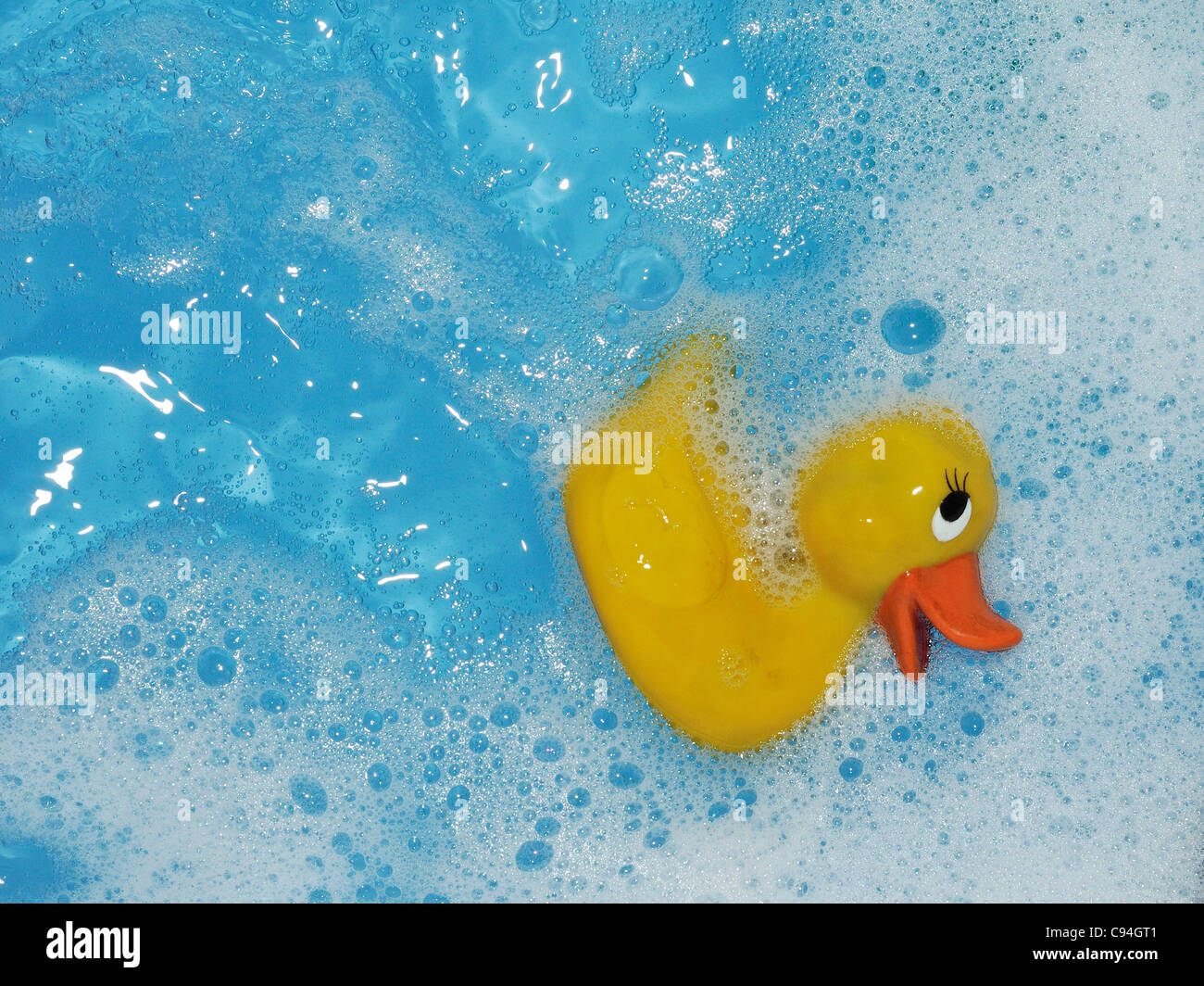 Toy rubber duck in bath with blue water Stock Photo - Alamy