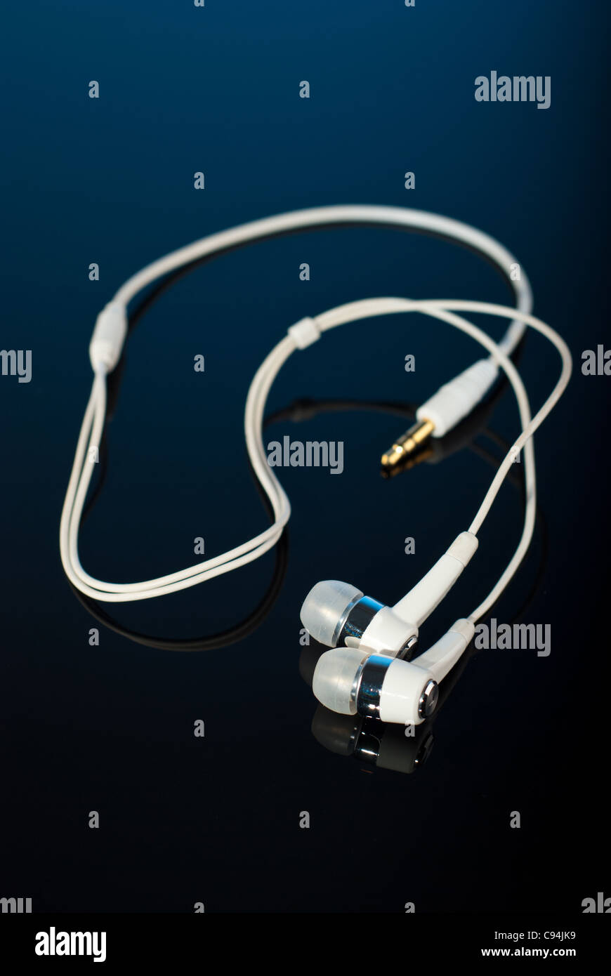 White earphones on black background with reflection Stock Photo