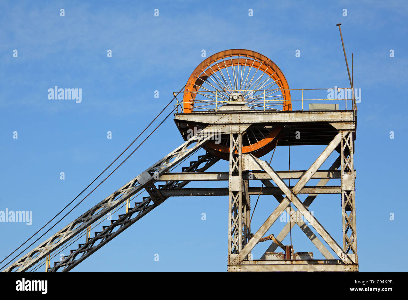 Old, disused mine shaft headgear with pulley wheel Stock Photo