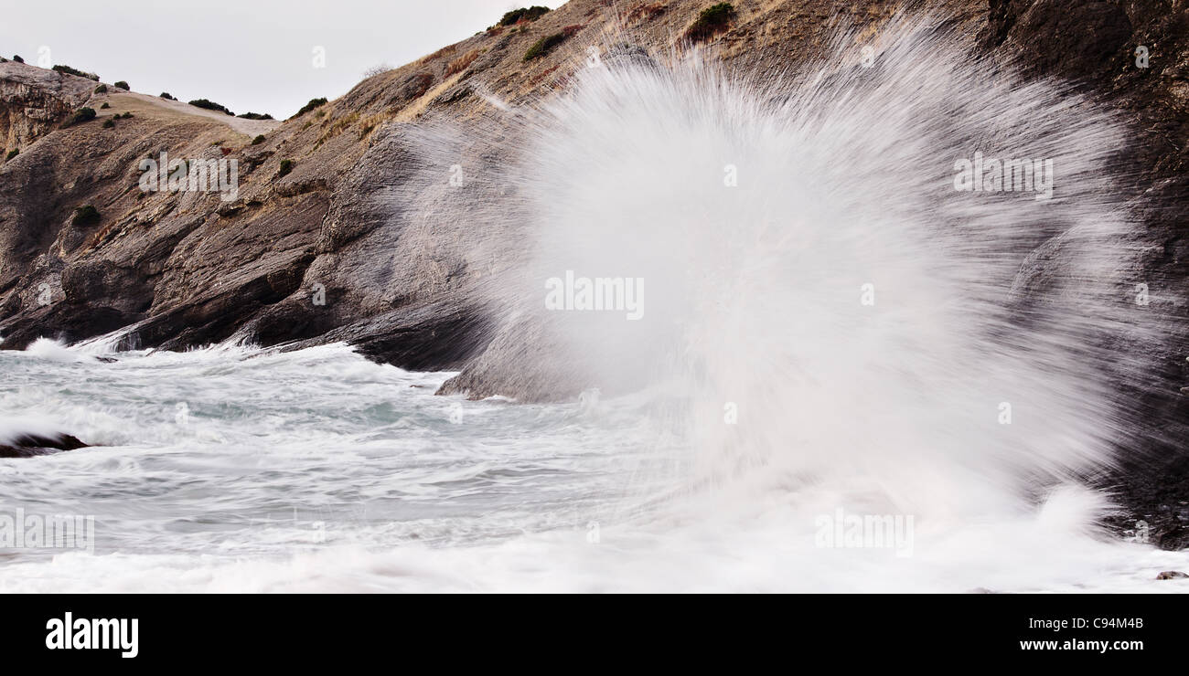 Stormy sea with crashing waves on rocks Stock Photo