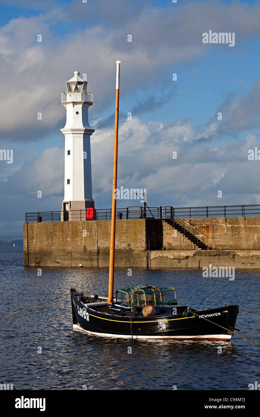 Fishing boat with Lighthouse in background in Newhaven Harbour, Leith, Edinburgh, Scotland UK Europe Stock Photo