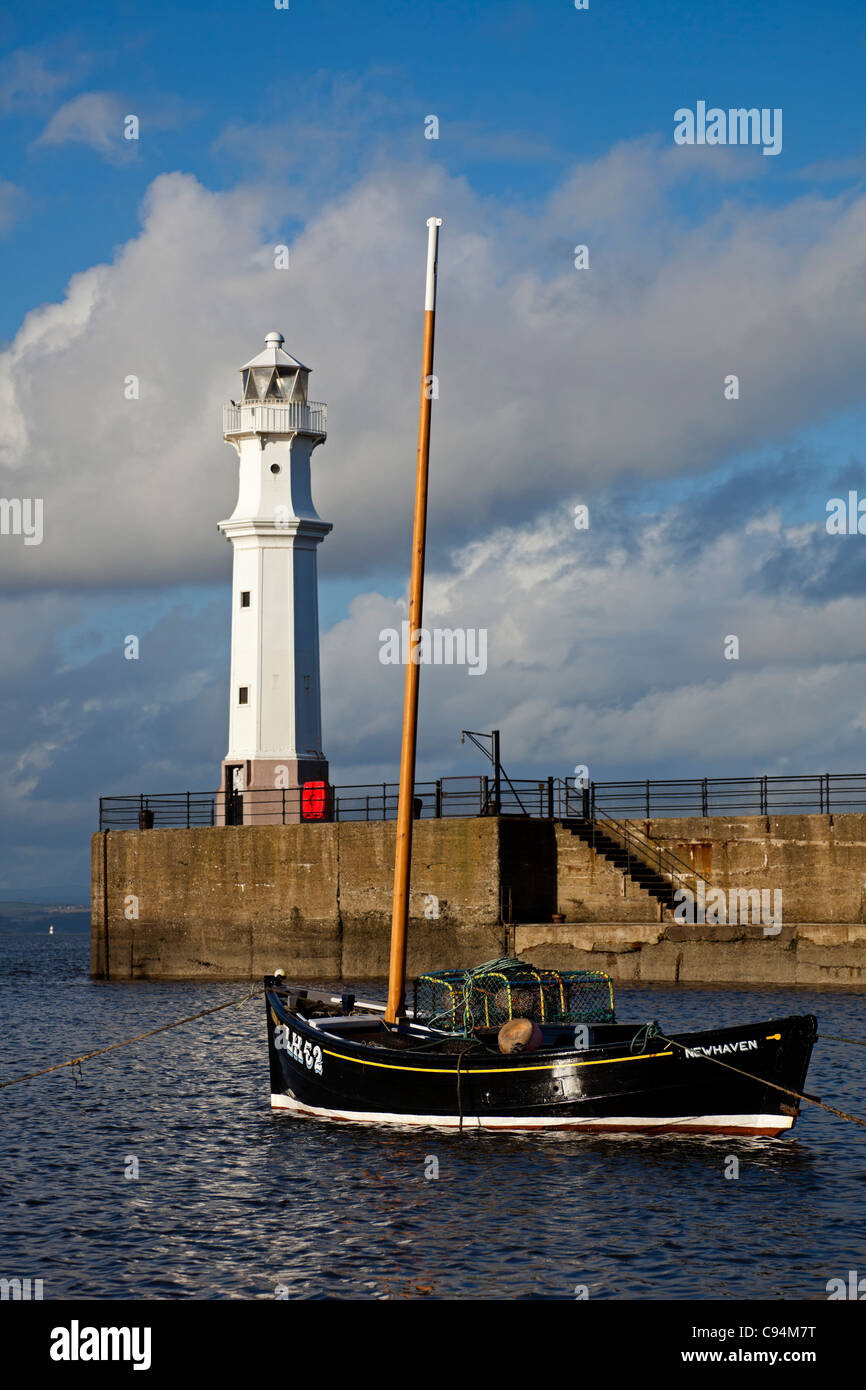 Fishing boat with Lighthouse in background in Newhaven Harbour, Leith, Edinburgh, Scotland, UK, Europe Stock Photo