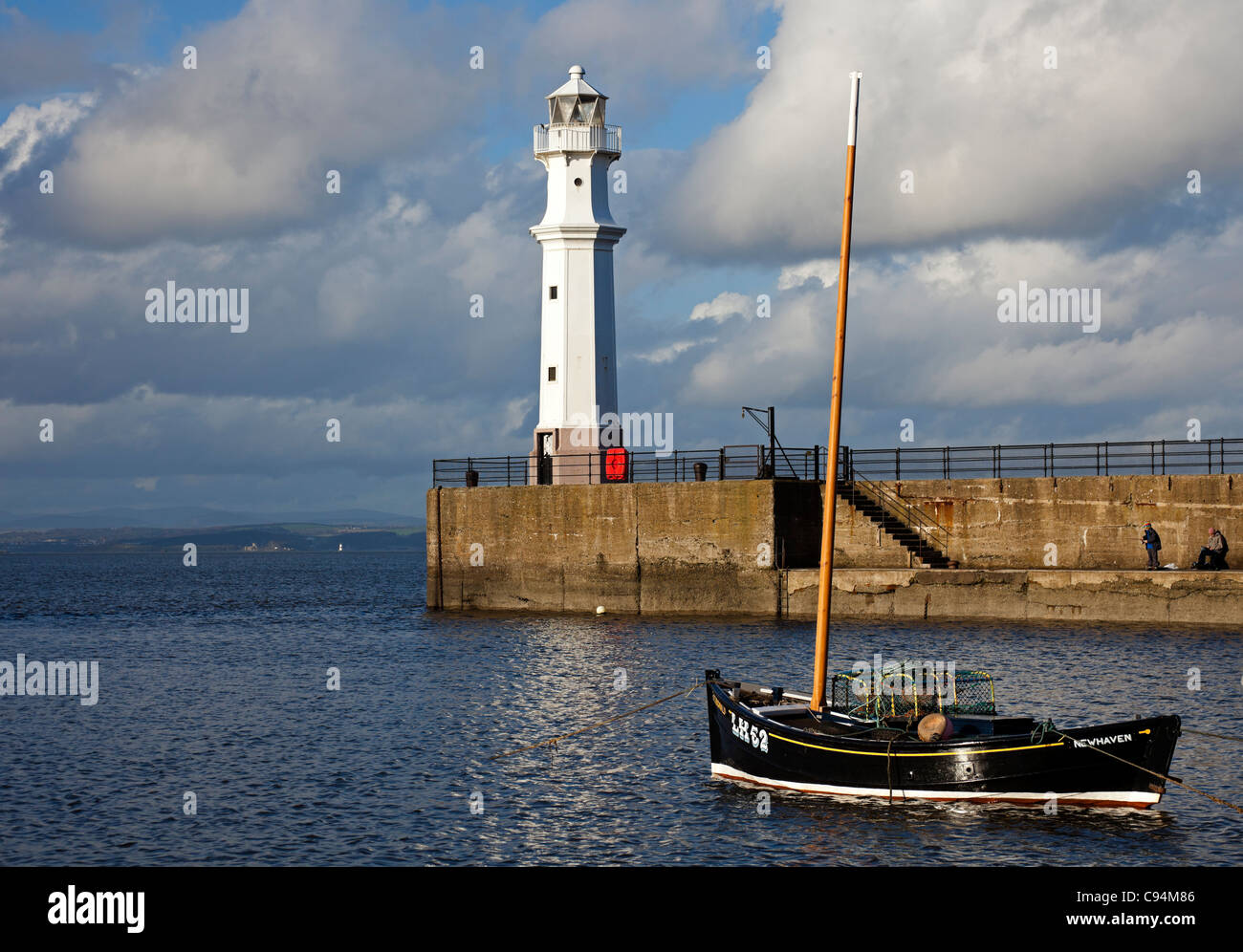 Fishing boat with Lighthouse in background in Newhaven Harbour, Leith, Edinburgh, Scotland UK Europe Stock Photo