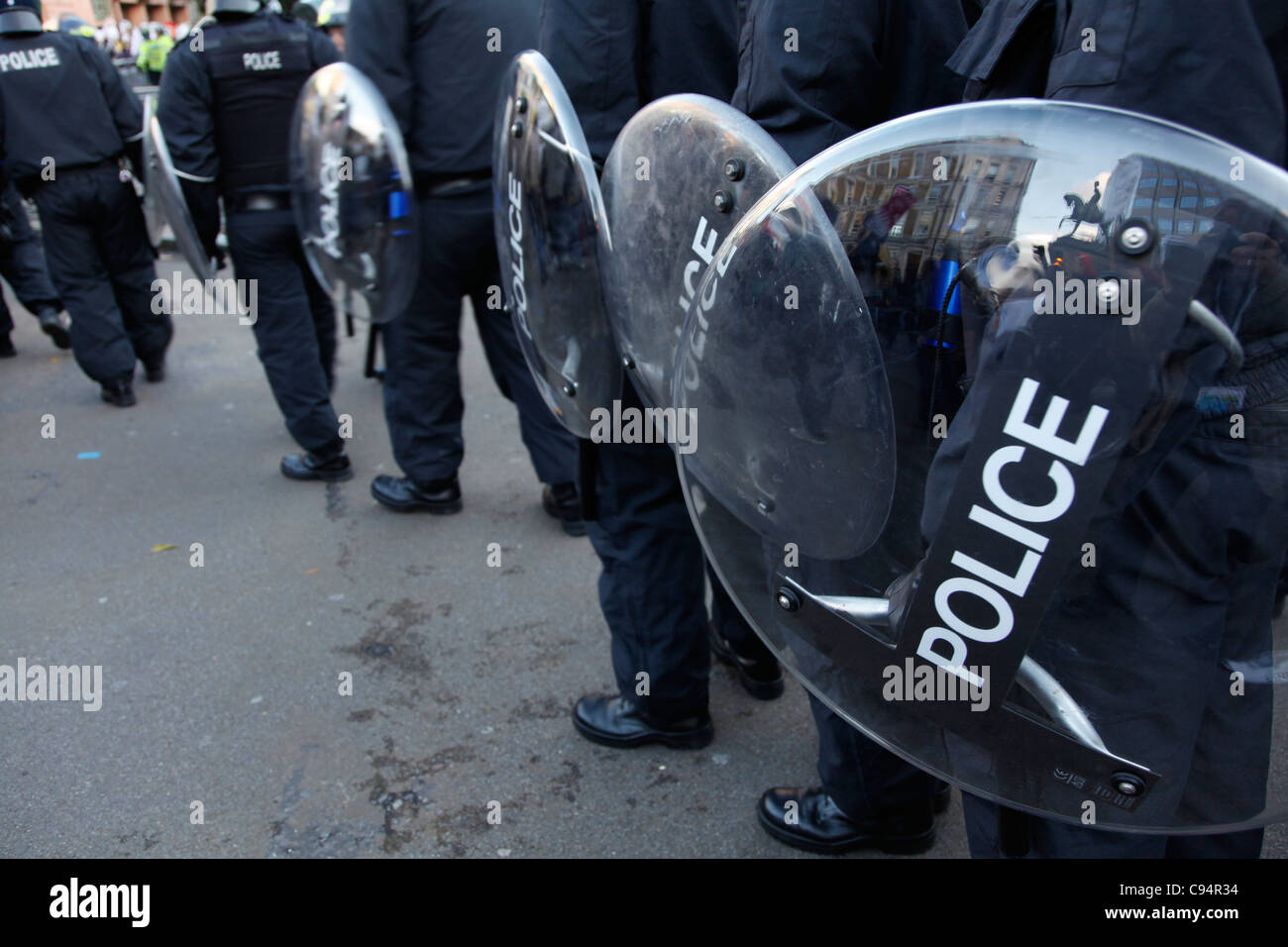 Police shields at emonstration against cuts in education past Occupy ...