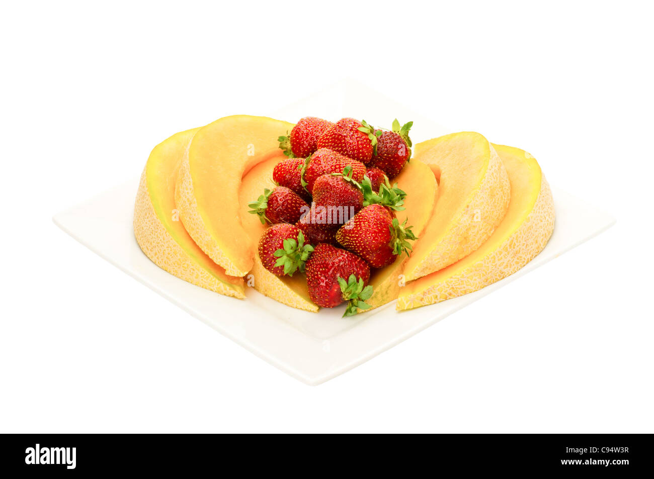 Fresh fruit desert of cantaloupe and strawberries on white plate Stock Photo
