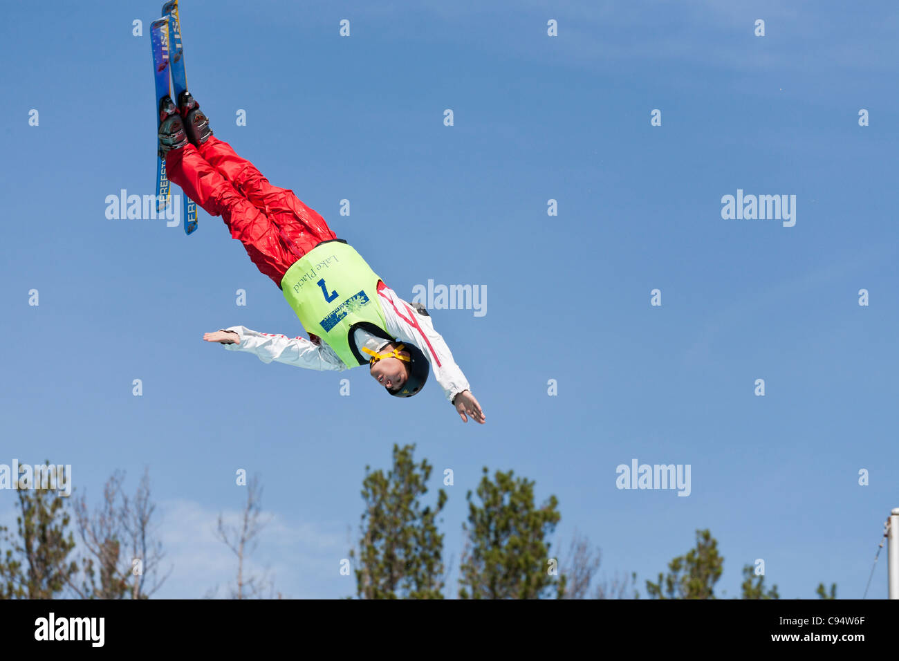 Head first into the waters/ trees. A freestyle skier eyeing the watery landing spot during summer practice for olympic sport Stock Photo