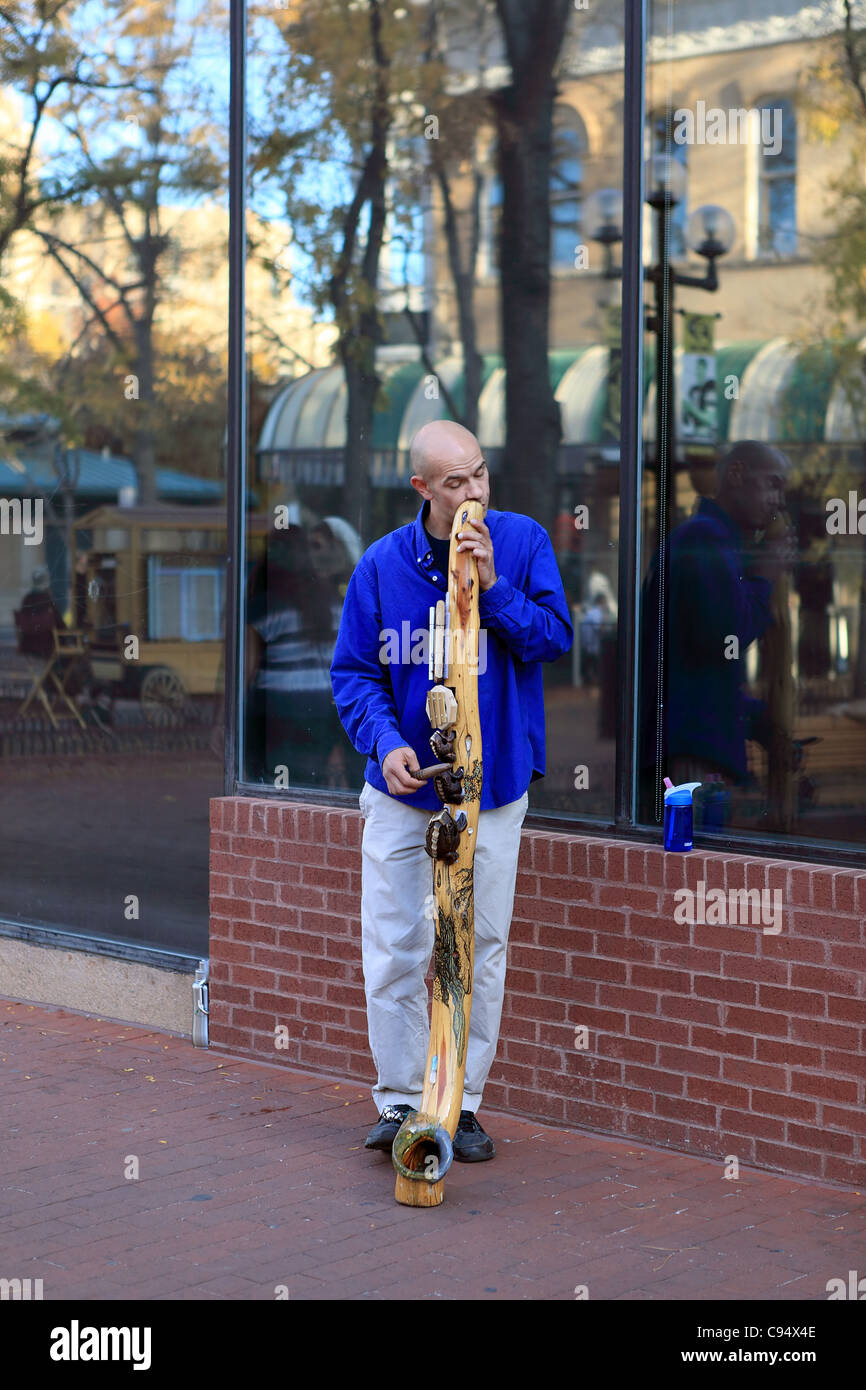 A busker plays the didgeridoo on Pearl Street Mall in Boulder Stock Photo