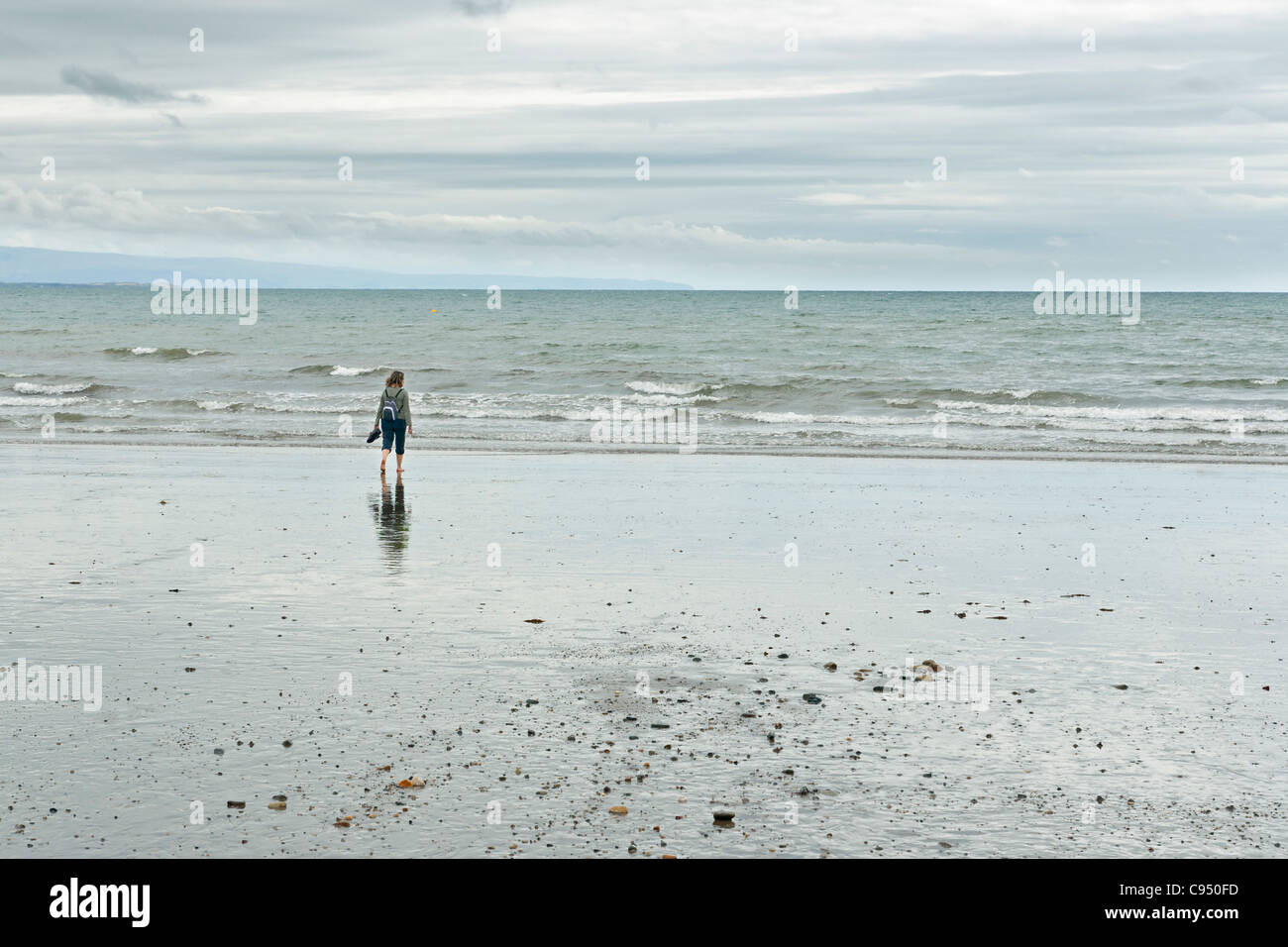 Woman at Criccieth beach in Wales, UK Stock Photo