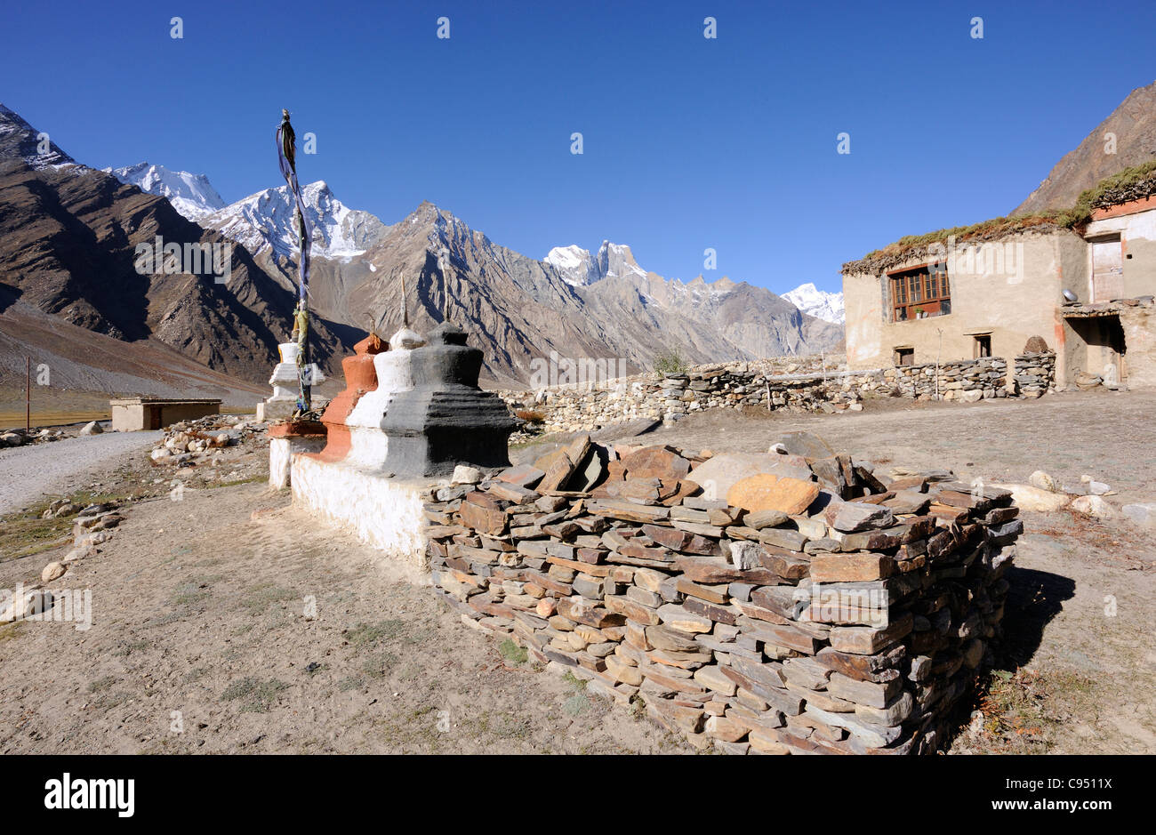 A traditional flat-roofed house and coloured stupas, chortens, on  the road from Kargil into the Zanscar valley. Stock Photo