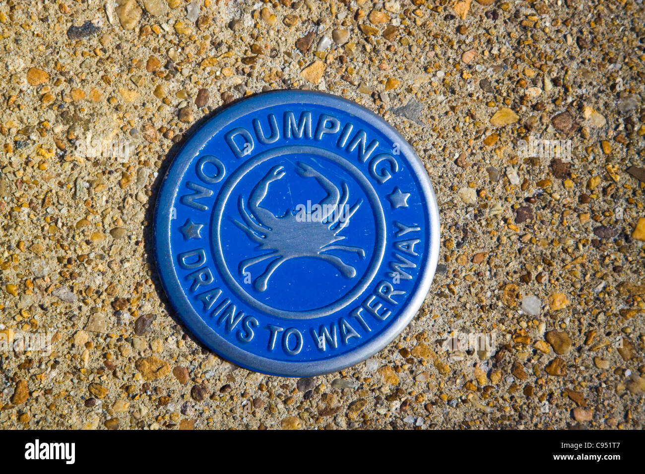 City of Williamsburg Virginia No Dumping Drains to Waterway sign on top of a storm drainage structure Stock Photo