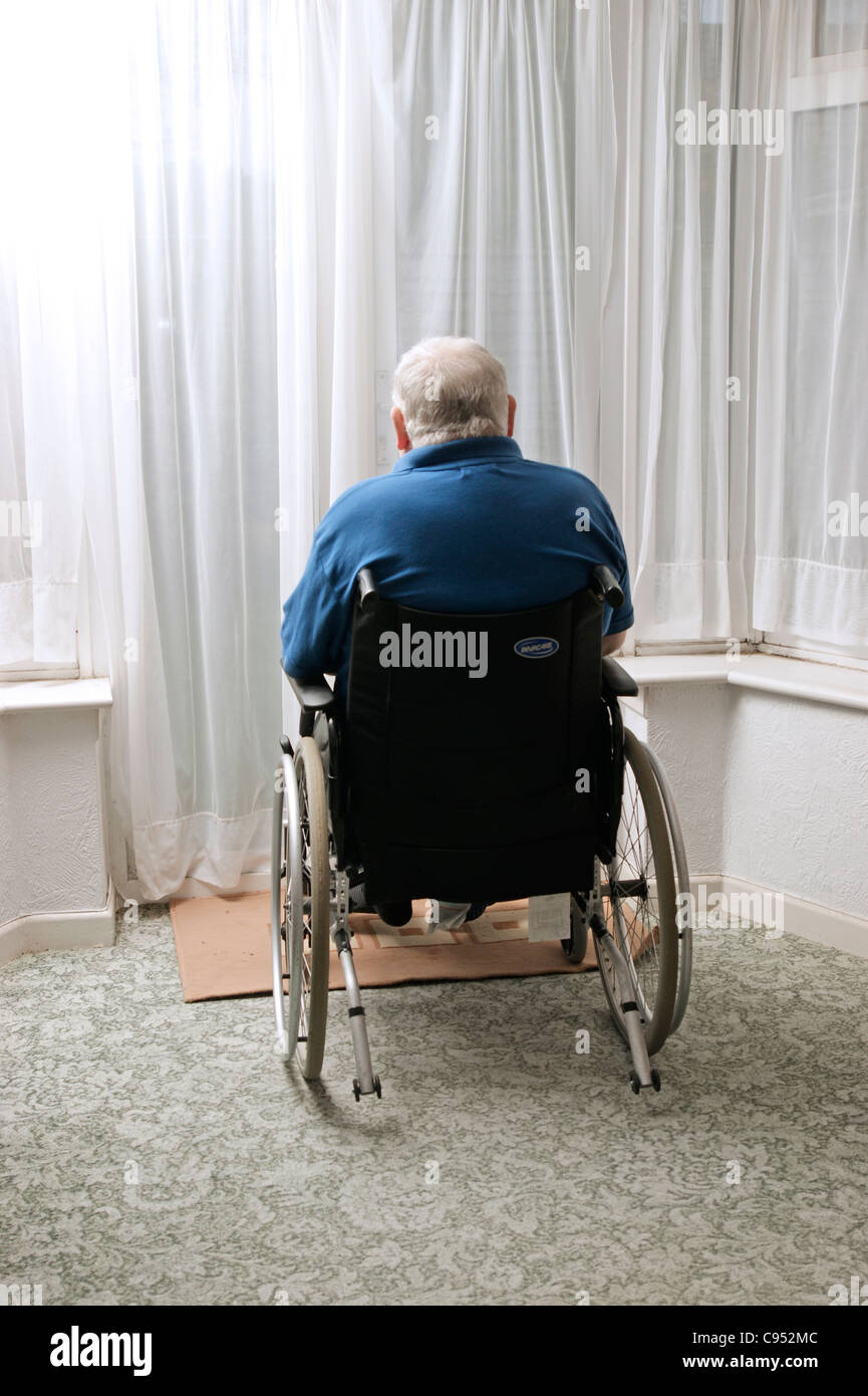 Disabled elderly man sitting in his wheelchair looking out of the ...