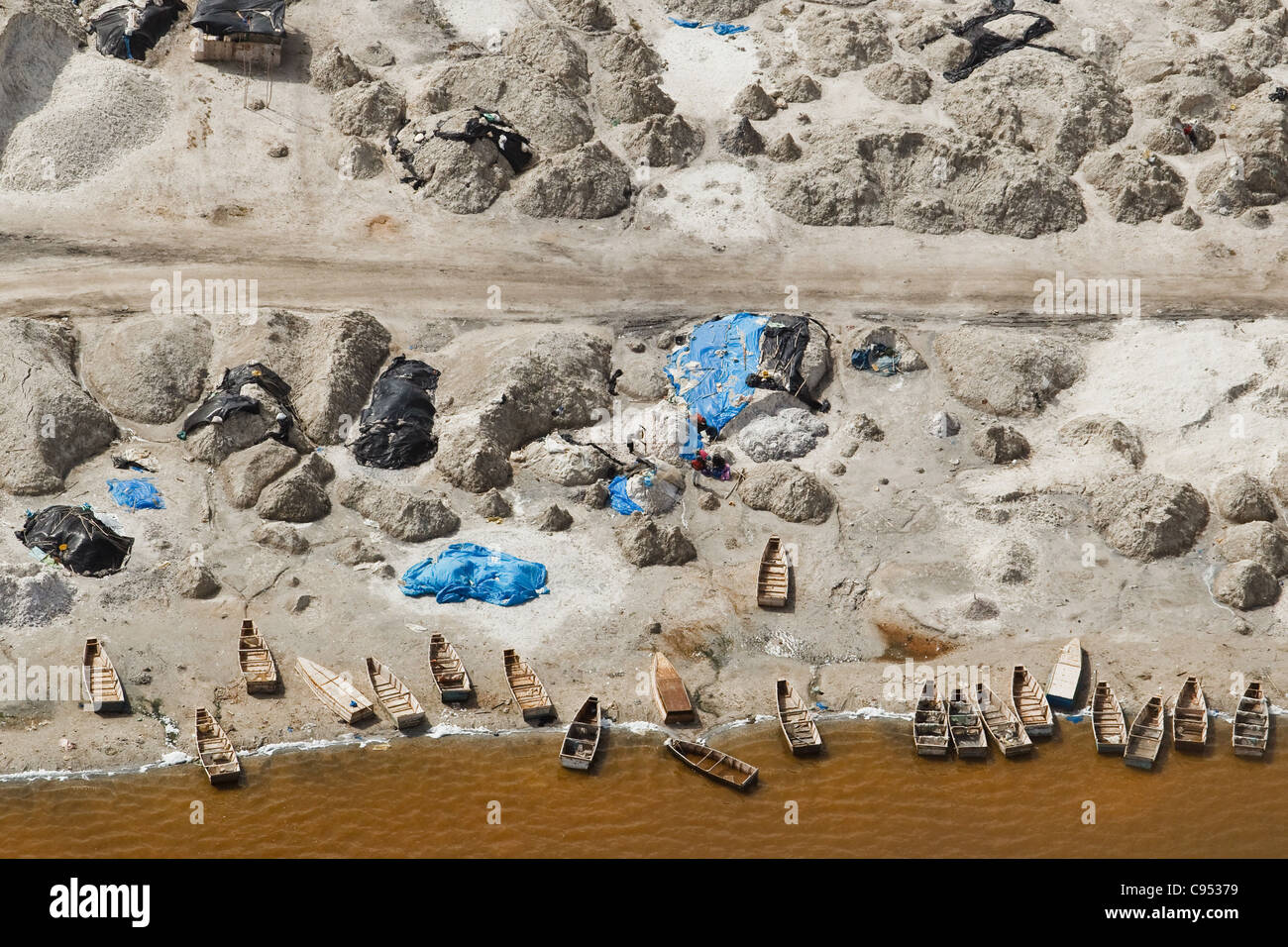 Pirogues and salt production on the shore of Lac Rose (Pink Lake) near Dakar, Senegal. Stock Photo