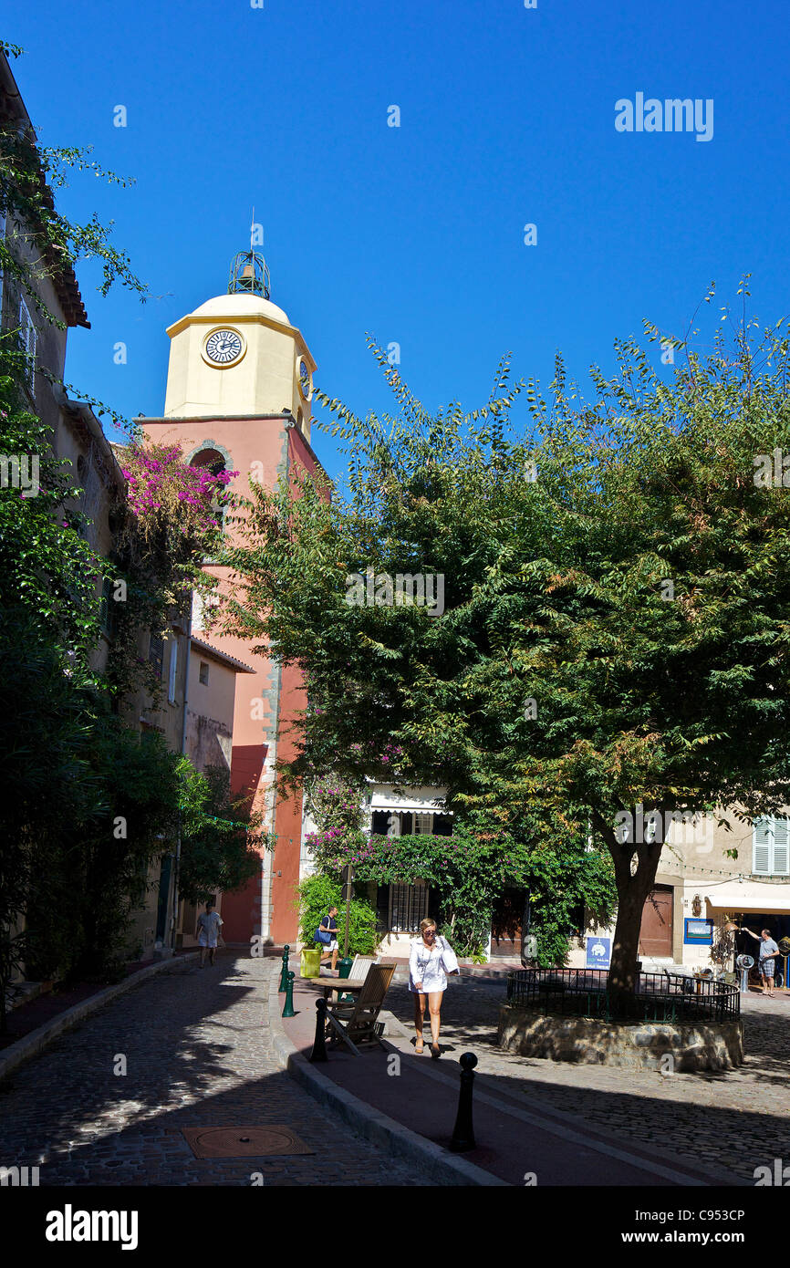 A backstreet in Saint-Tropez, with the bell tower of Notre Dame de L’Assomption, Var, Provence, Cote d'Azur, France Stock Photo