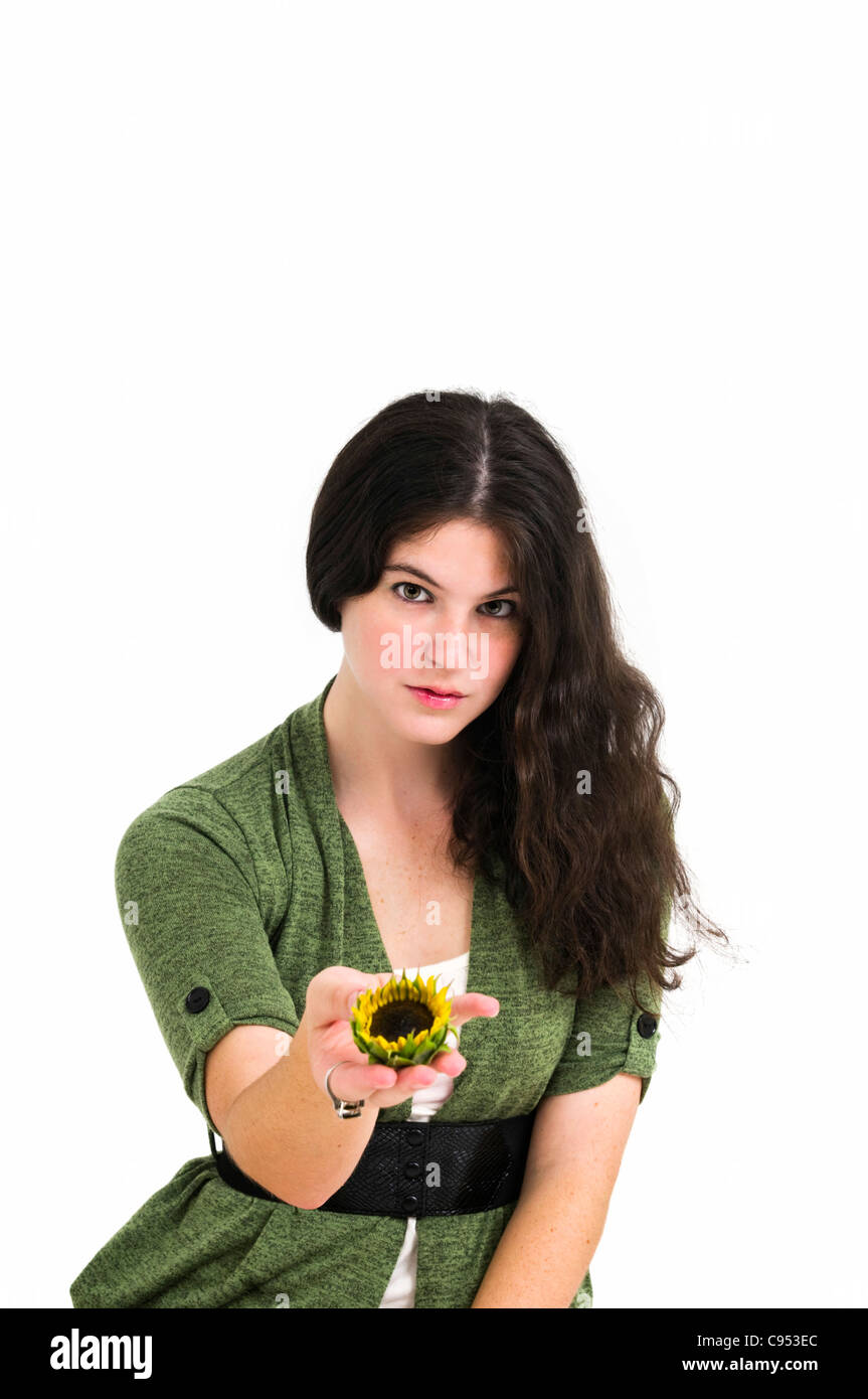 Young female teen offers the viewer a sunflower in the palm of her hand ...