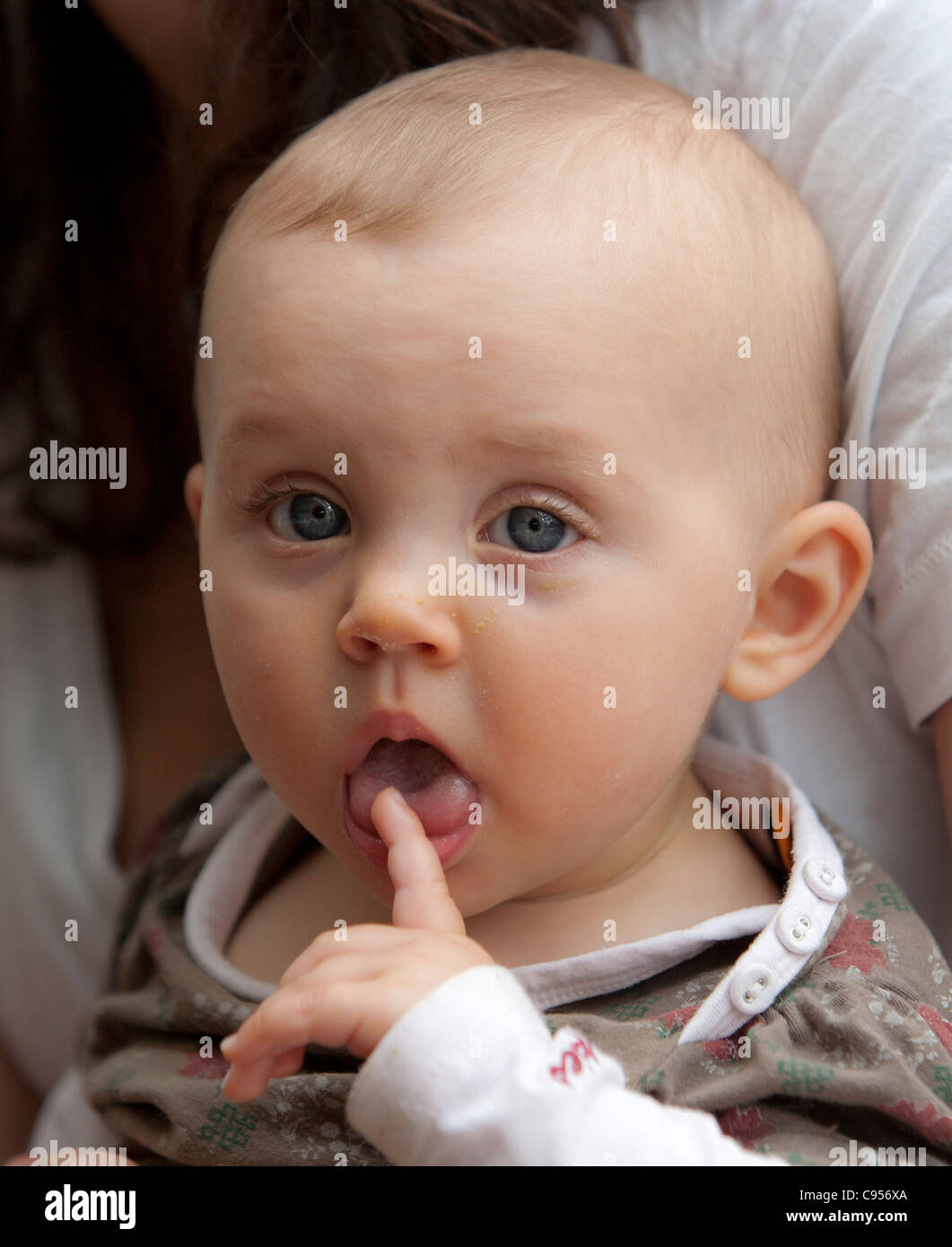 Oneyearold child licking her finger Stock Photo Alamy